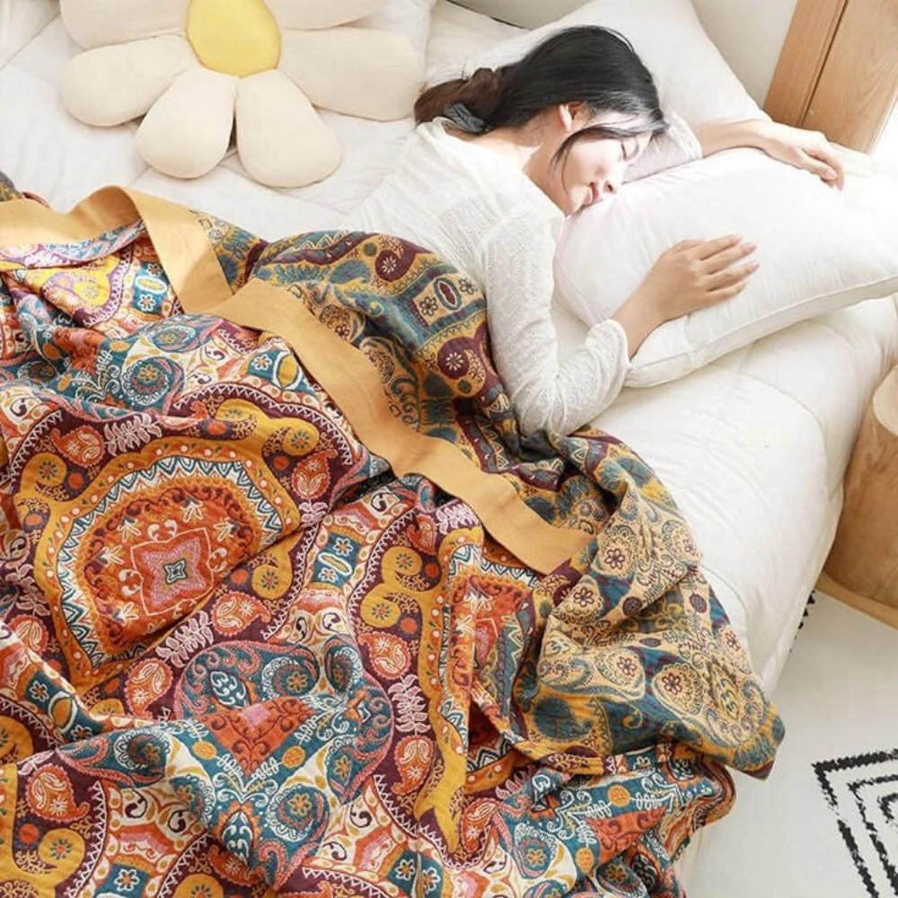 Colorful Boho Paisley Quilt featuring a vibrant and intricate vintage patchwork design, draped over a couch for a cozy and comfortable look, highlighting its artistic pattern and luxurious textile quality.