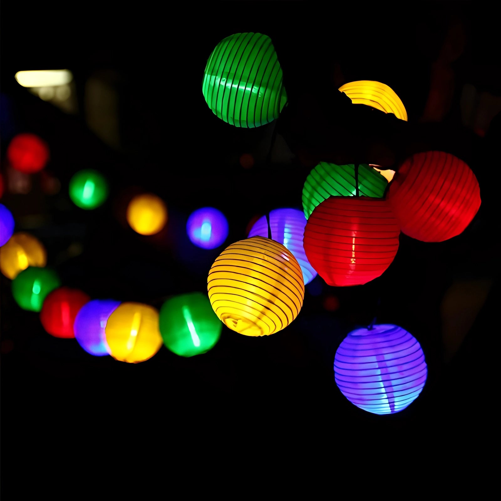 Colorful LED outdoor string lights featuring weatherproof multicolor lanterns with a total length of 6.5 meters and 30 LEDs. The image shows circular lanterns emitting vibrant colors, creating a festive atmosphere in the dark, suitable for events and outdoor decoration.