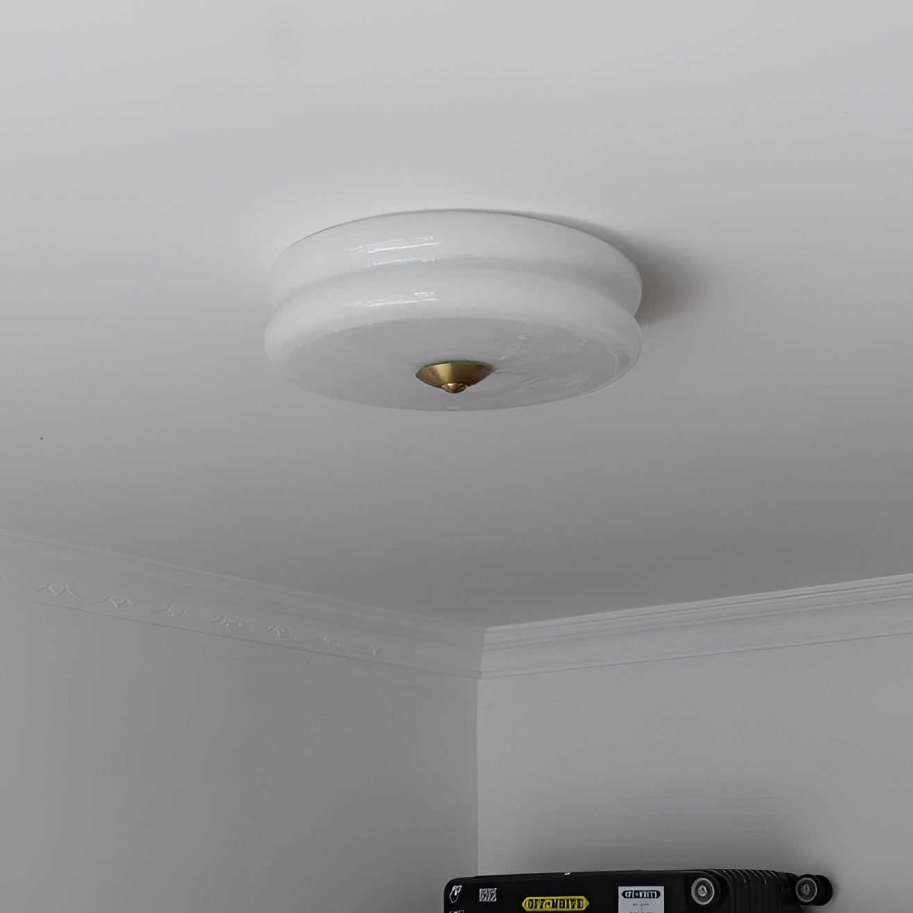 Modern cream ceiling lamp featuring a frosted glass fixture, mounted on a plaster ceiling, designed to enhance home decor with its circular shape and soft illumination.
