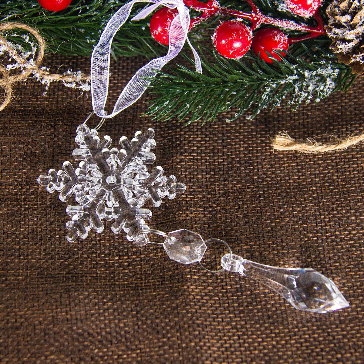 Crystal snowflake ornaments made of luxury glass with intricate silver embellishments, perfect for Christmas decor, displayed against a textile background.
