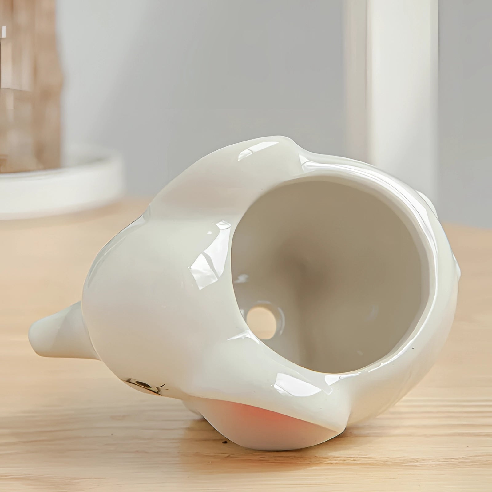 Small beige ceramic cow planter with a charming animal theme, suitable for indoor decor, placed on a wooden surface.