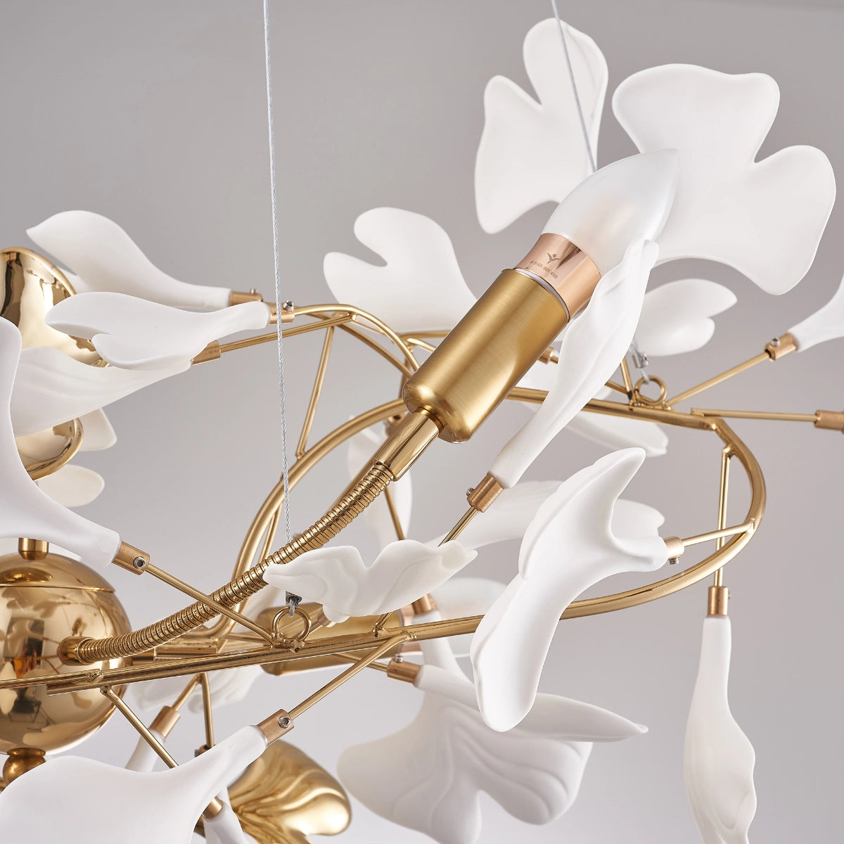 Designer Ginkgo Leaf LED Chandelier with elegant metallic and wood elements, featuring a modern design inspired by natural twig and petal shapes, suspended from the ceiling to illuminate a luxurious kitchen space.