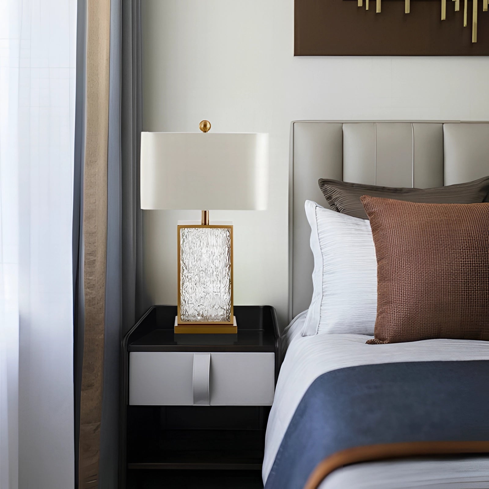 Designer table lamp with a luxurious gold base and a white shade, placed in a modern interior setting, emphasizing contemporary decor elements.