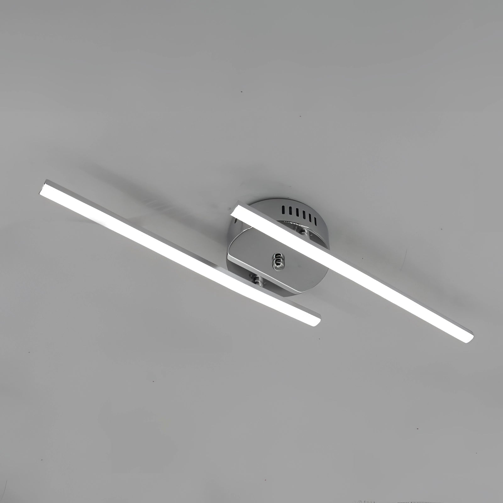 Dual-arm adjustable LED wall sconce with a modern minimalist design, featuring a circular light fixture made of metal, mounted on a wall.