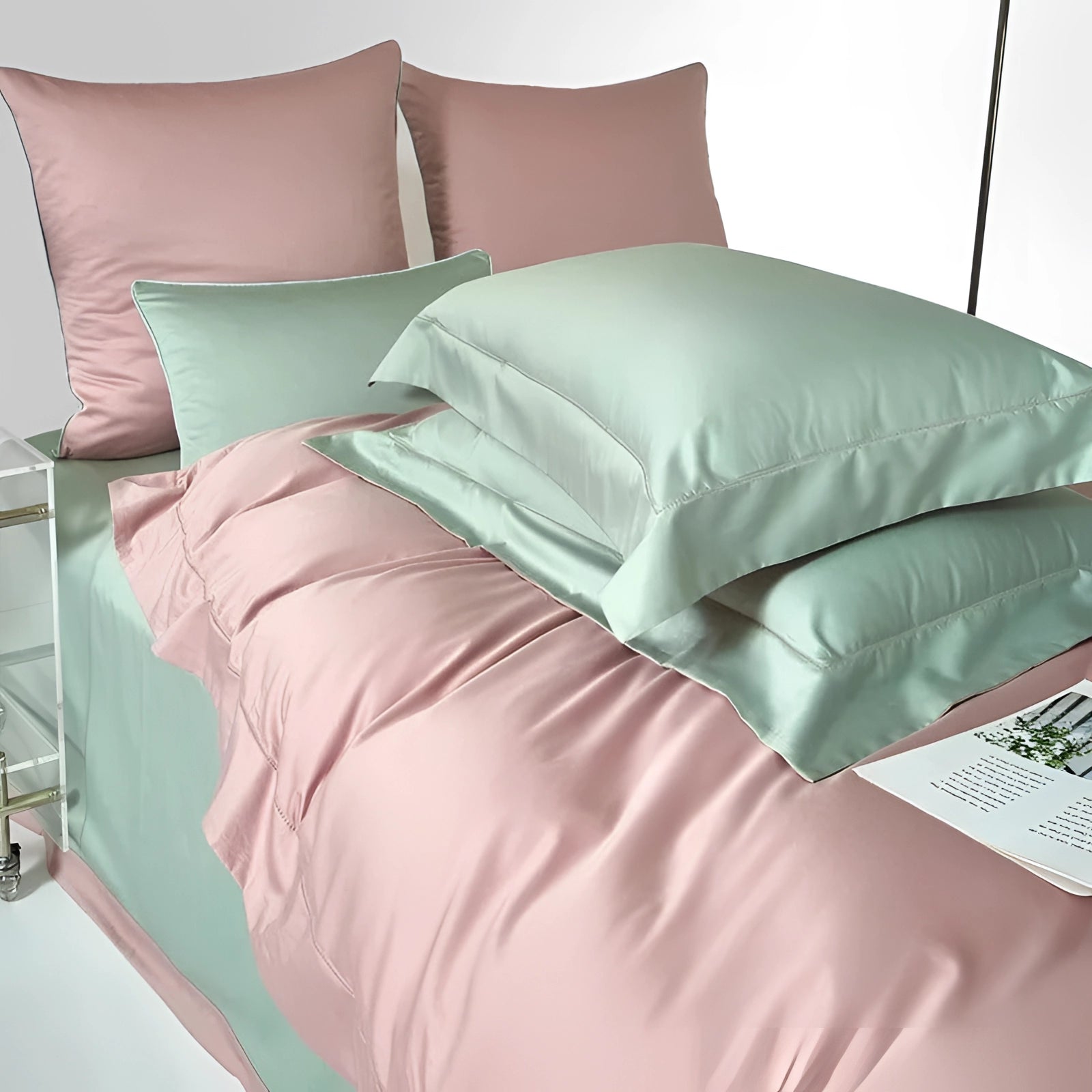 Dual-color Egyptian cotton duvet set in pink and green, featuring a neatly arranged bed with plush pillows, surrounded by a modern interior design that includes a wooden bed frame, flooring, and a bedside lamp.