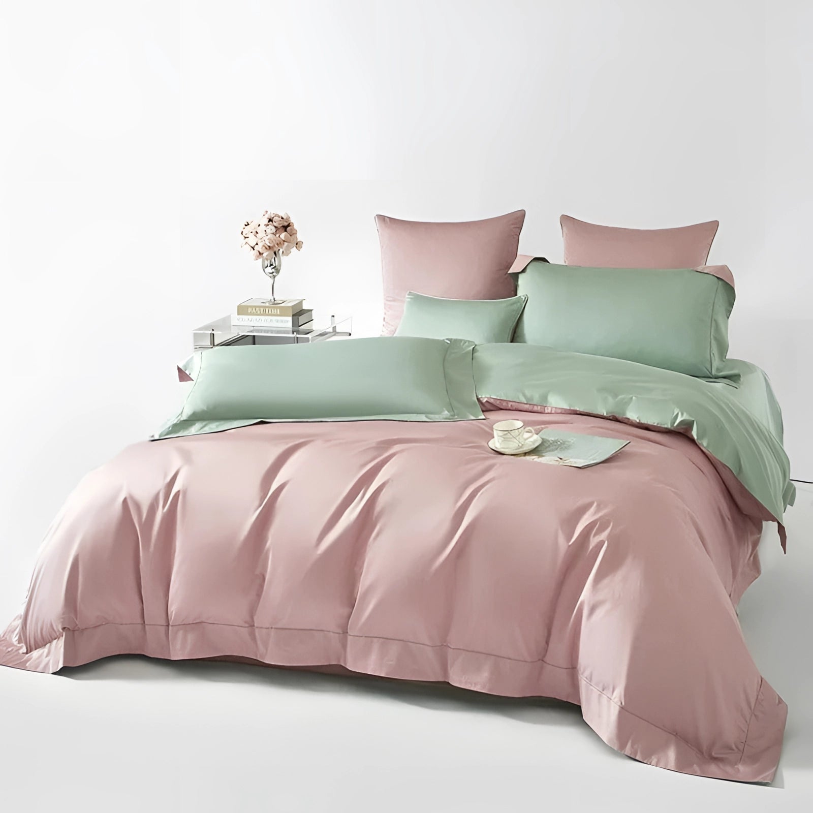 A dual-color Egyptian cotton duvet set in shades of pink and green on a neatly made bed, featuring matching pillows against a neutral-toned bed frame.