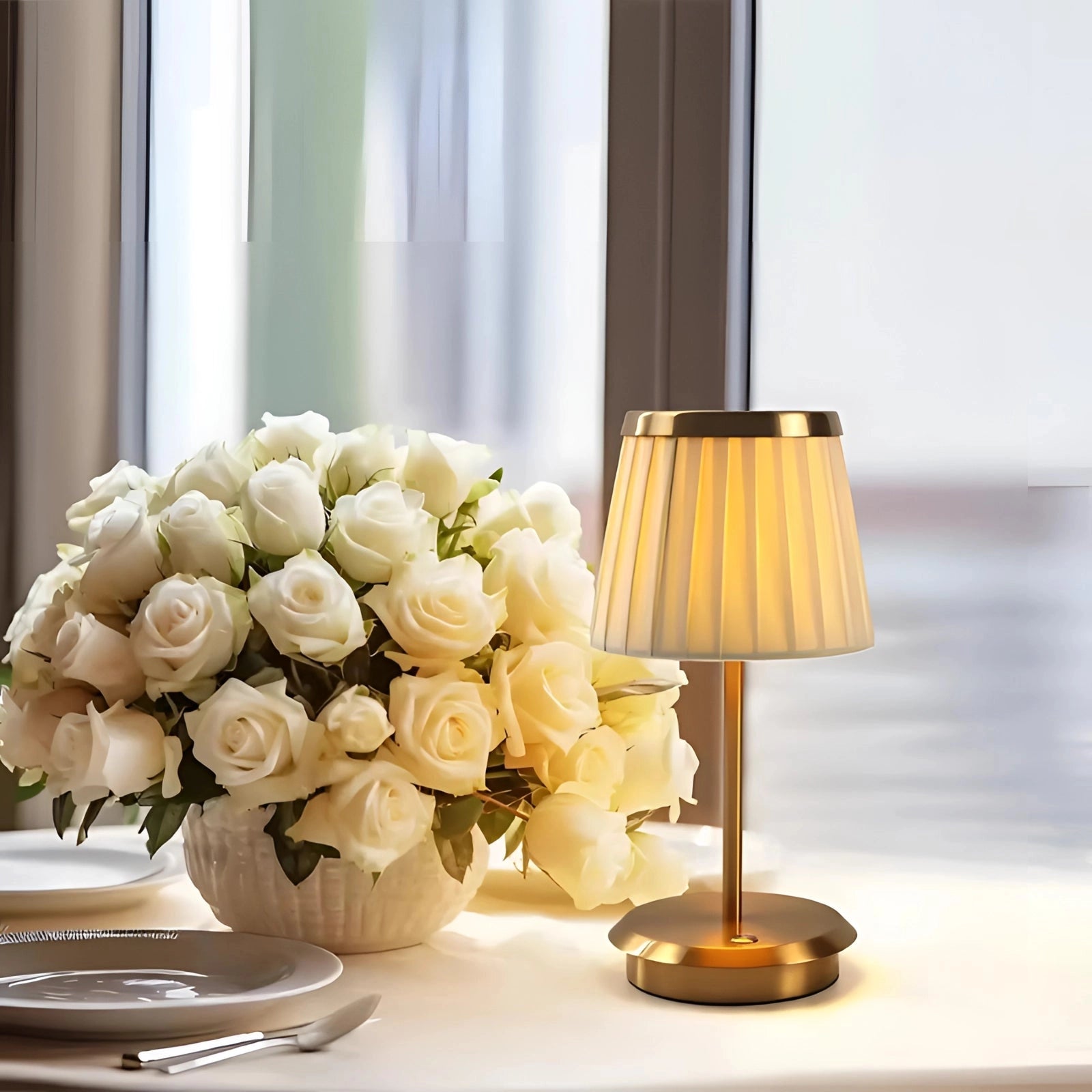 An elegant cordless LED outdoor lamp placed on a table next to a vase with orange flowers and drinkware, set in a stylish and cozy interior design ambiance.