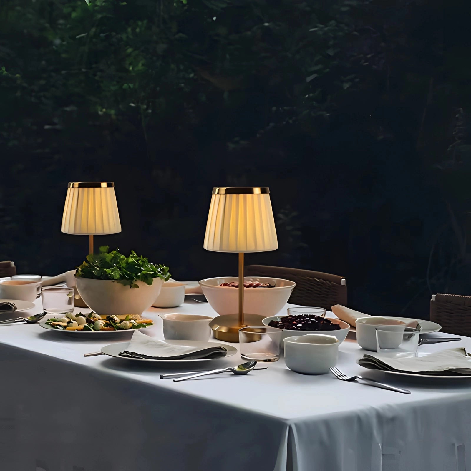 Elegant Cordless LED Outdoor Lamp placed on a table set with tableware, including cups, plates, and a tablecloth, illuminating the scene with a warm glow.