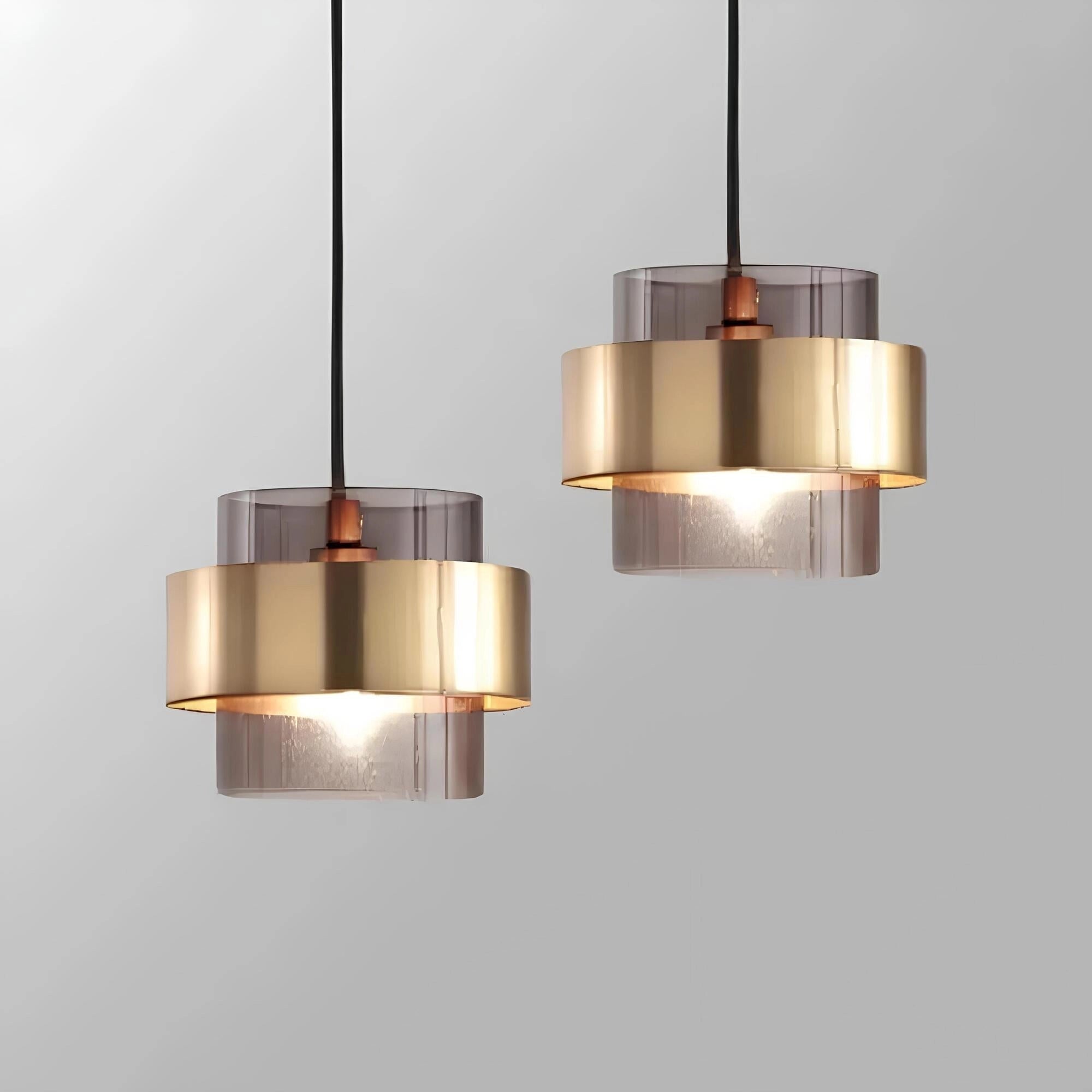 Elegant gold-brass pendant chandelier with adjustable height, featuring a cylindrical metal and glass design, suspended from a rectangular wooden ceiling mount.