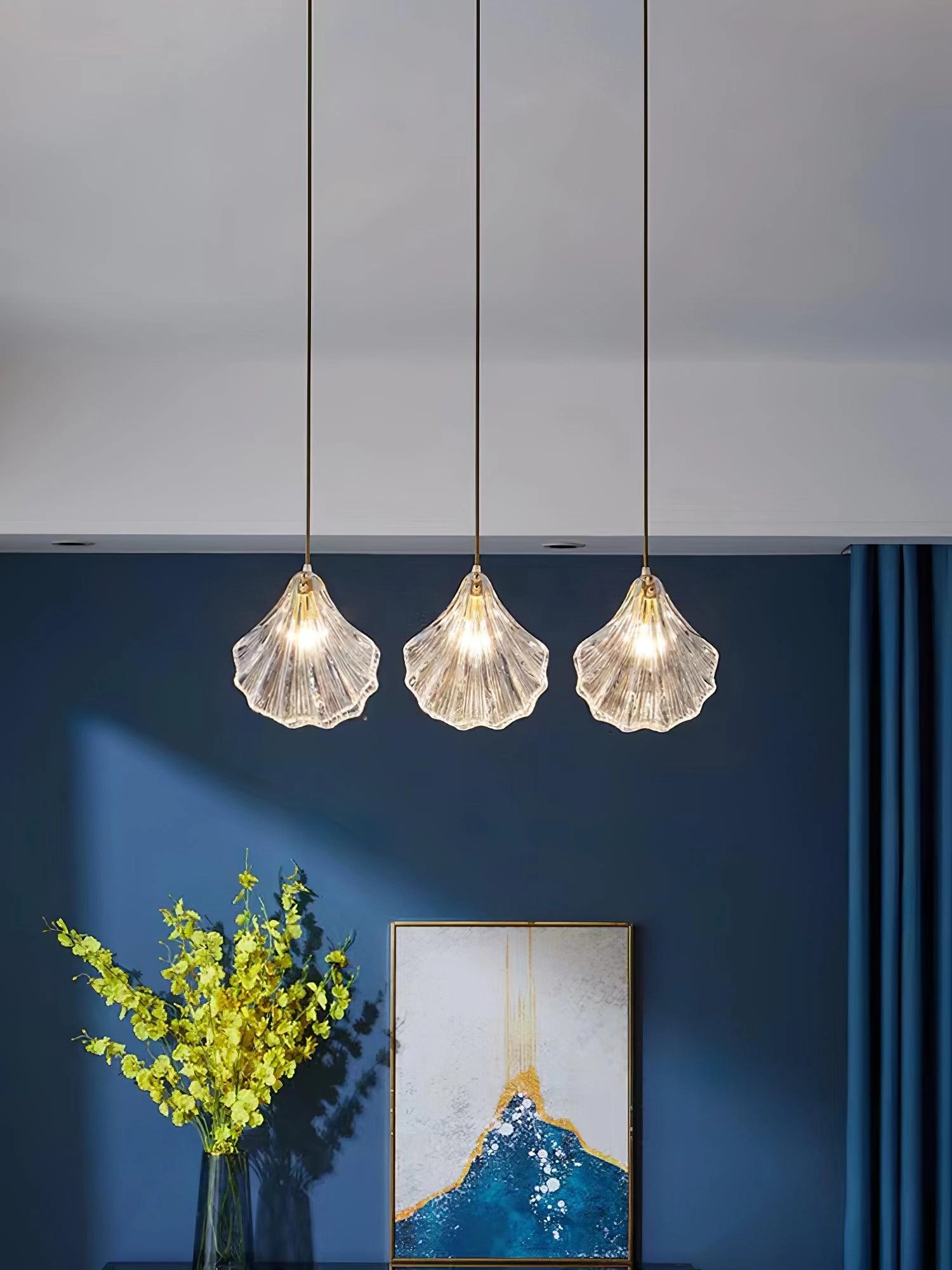 Elegant petal glass pendant light in the shape of a flower, featuring modern LED lighting, hanging in a stylishly designed interior with natural elements.