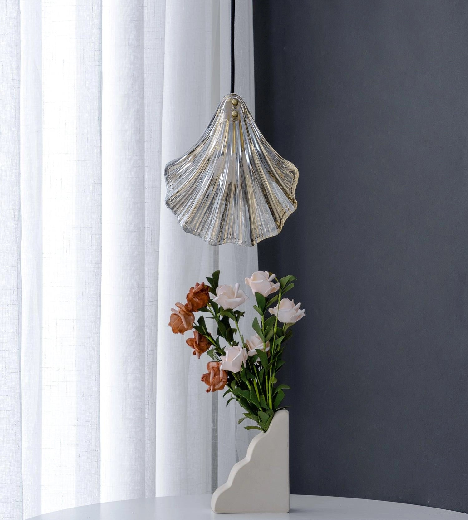 Modern LED chandelier with an elegant petal glass design, resembling a floral arrangement, hanging in a stylishly decorated room.