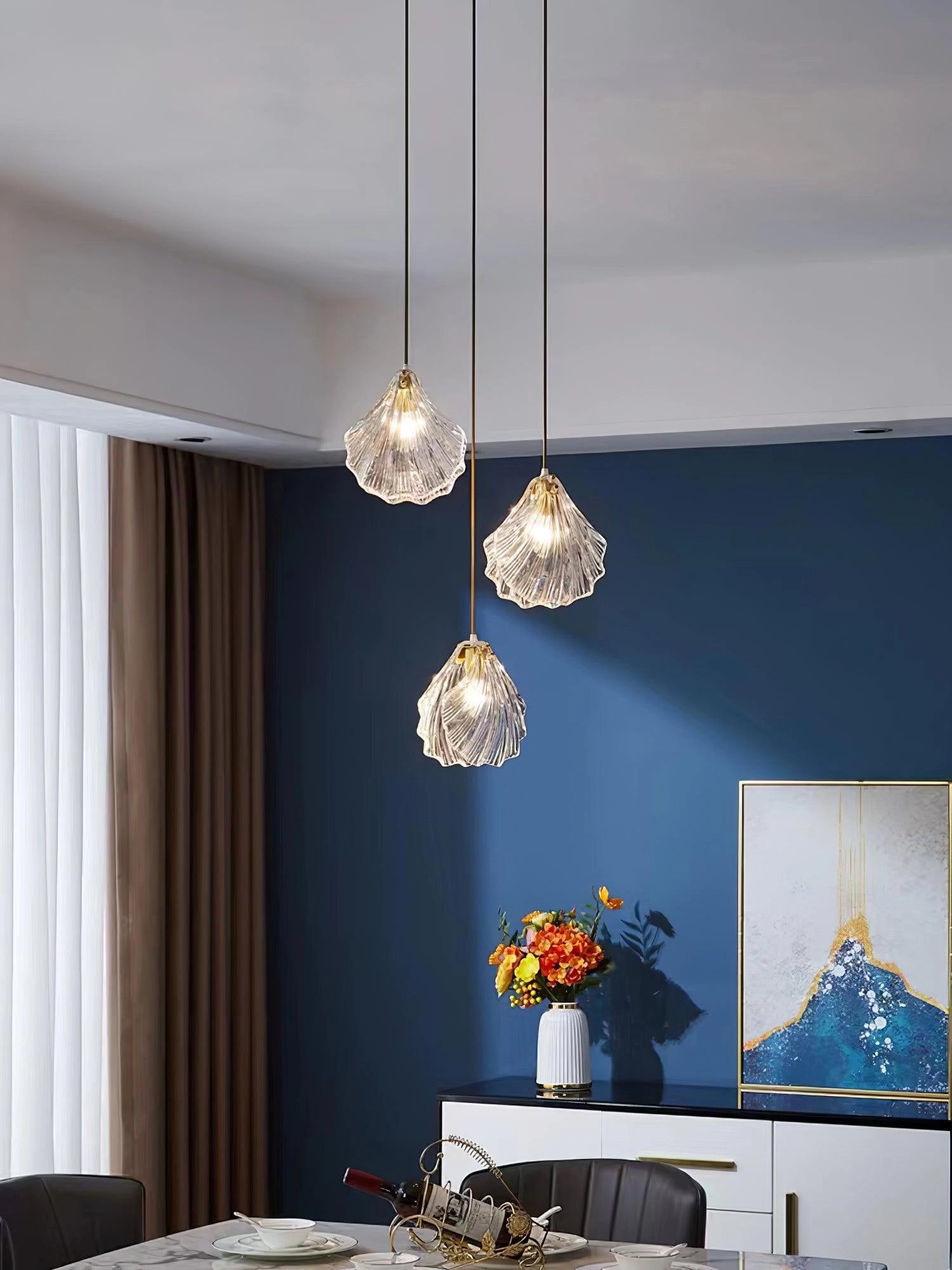Elegant Petal Glass Pendant Light with three heads and a diameter of 30cm, featuring a modern LED floral chandelier design in a brass and clear finish, hanging in a stylishly furnished interior.