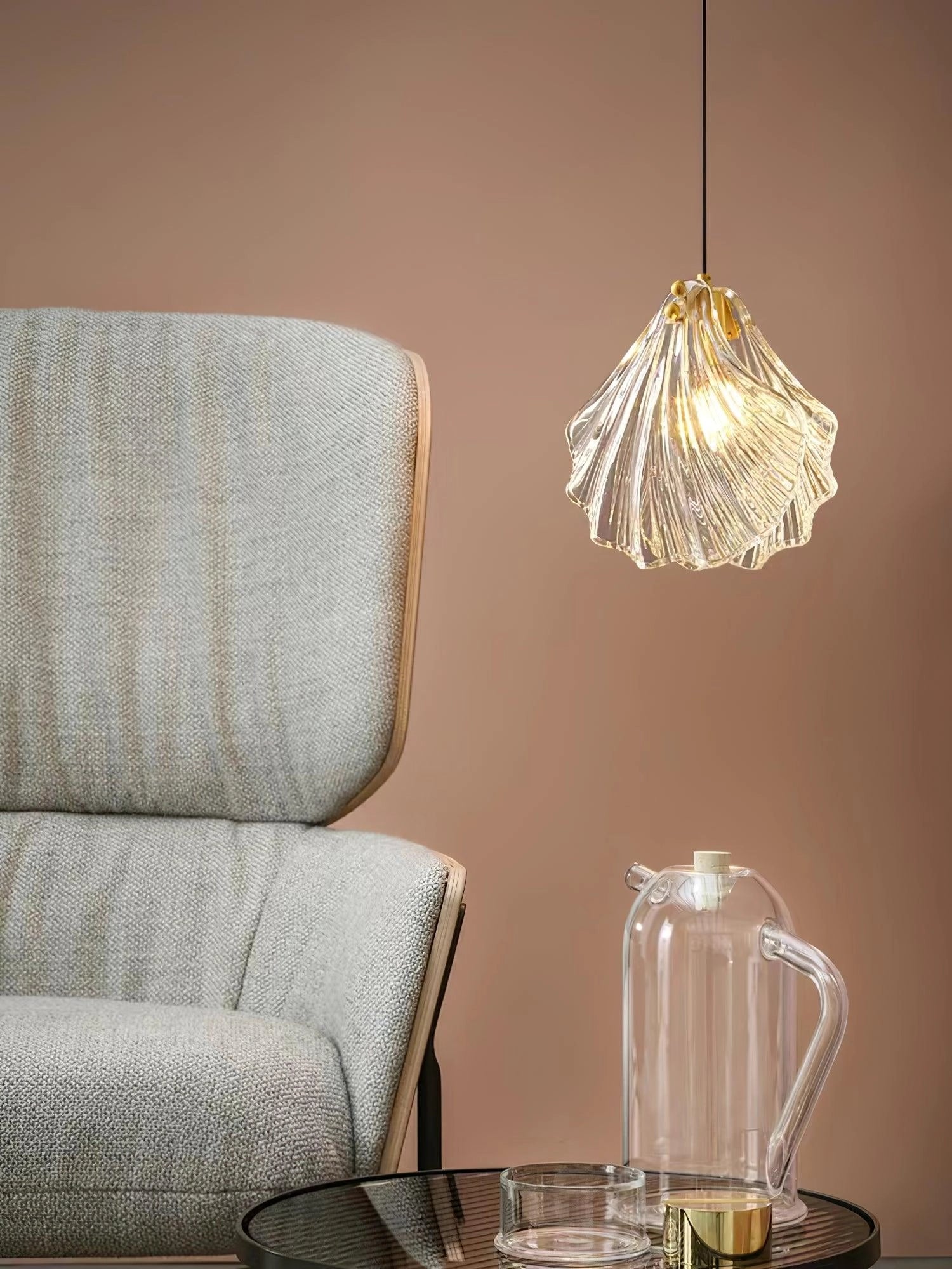 Elegant Petal Glass Pendant Light with modern floral design illuminating a stylish interior space featuring a couch, wood accents, and tasteful decor.