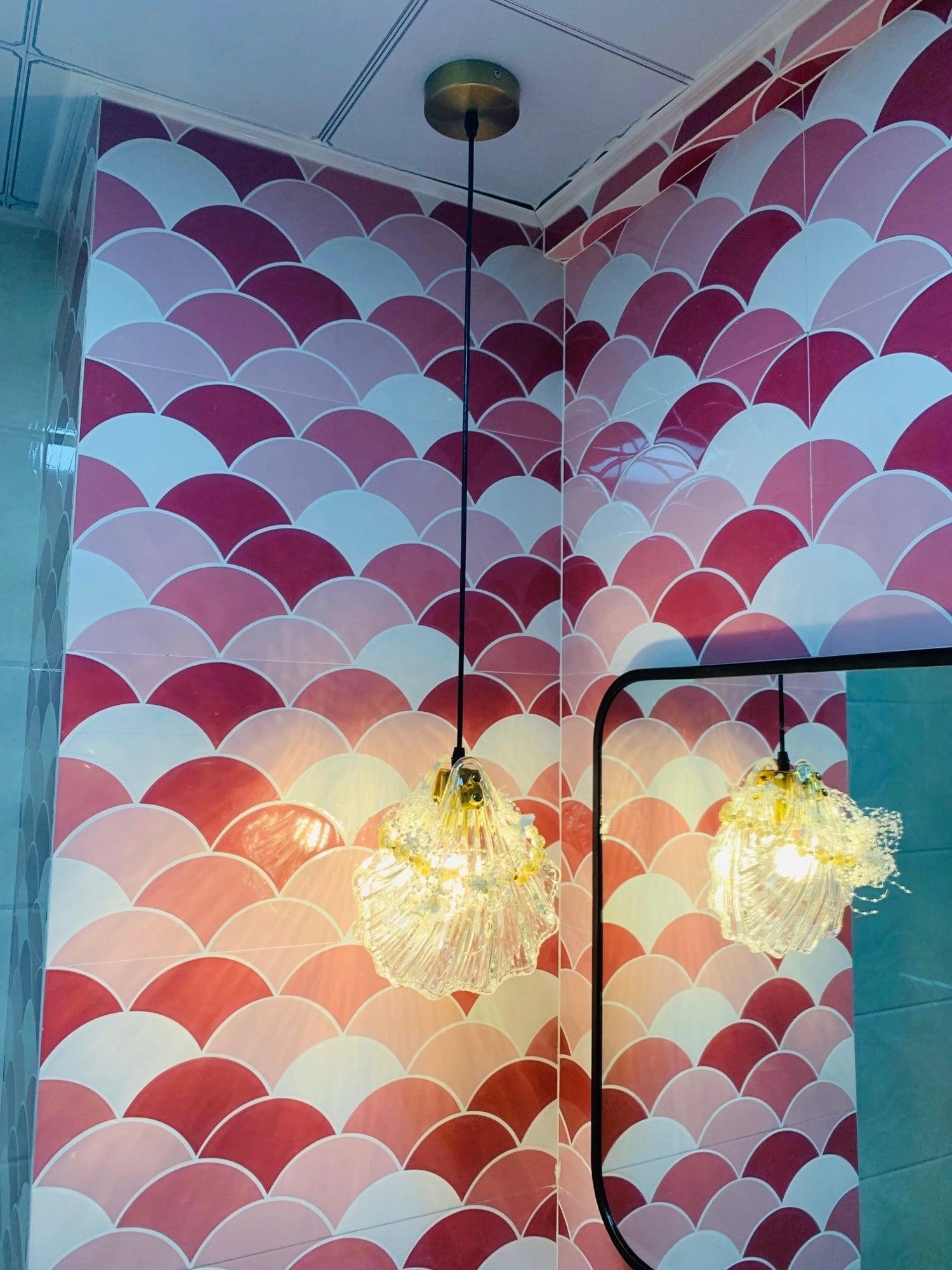 Elegant Petal Glass Pendant Light with modern LED floral design, illuminating an orange interior space with artistic and architectural elements.