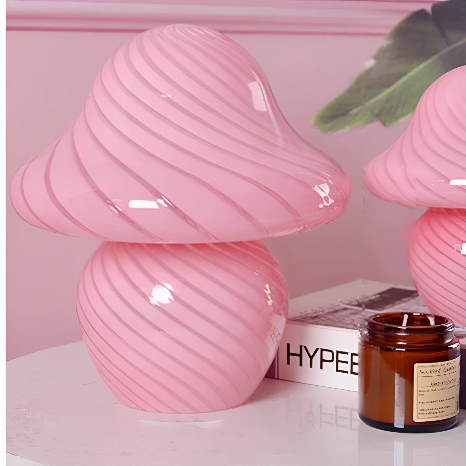 Elegant white spiral table lamp with a large pink swirl design, featuring a modern sculptural shape and vibrant magenta highlights.