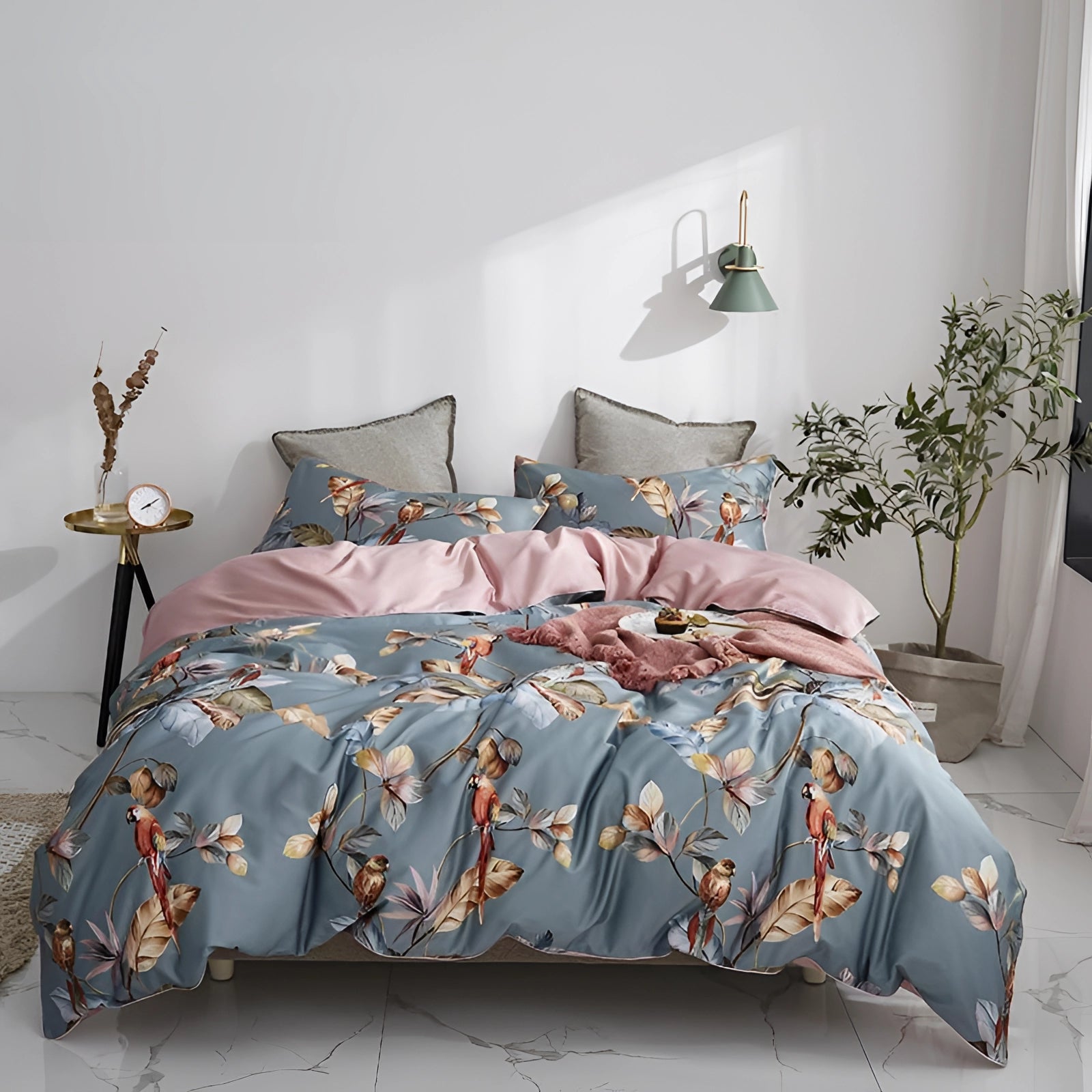 Luxurious comforter set with a floral botanical design and butterfly motifs displayed on a neatly made bed with a grey wooden bed frame in a well-designed interior space.