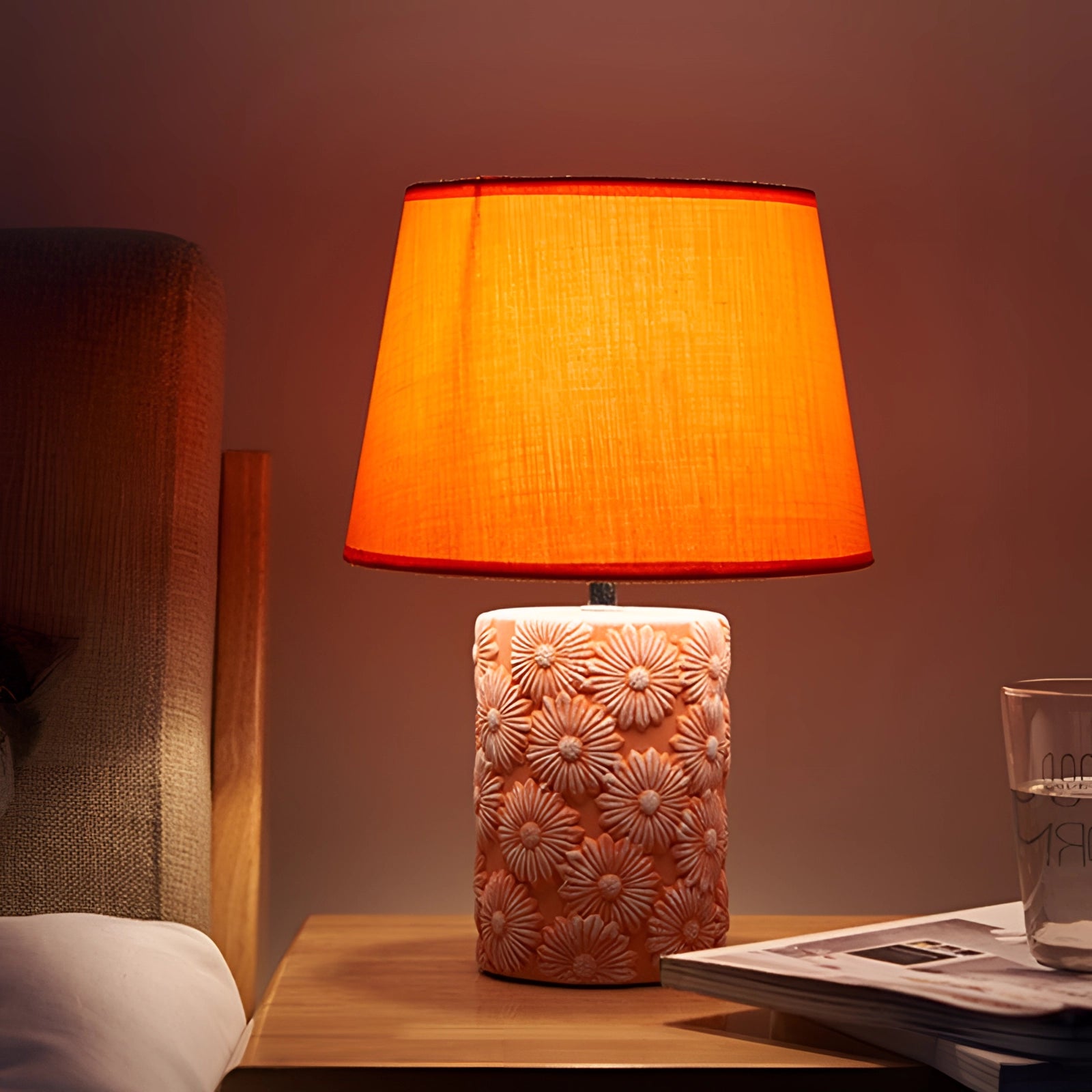 Floral ceramic table lamp with a sunflower base featuring a rectangular amber and orange textile shade, designed for artisan bedroom lighting.