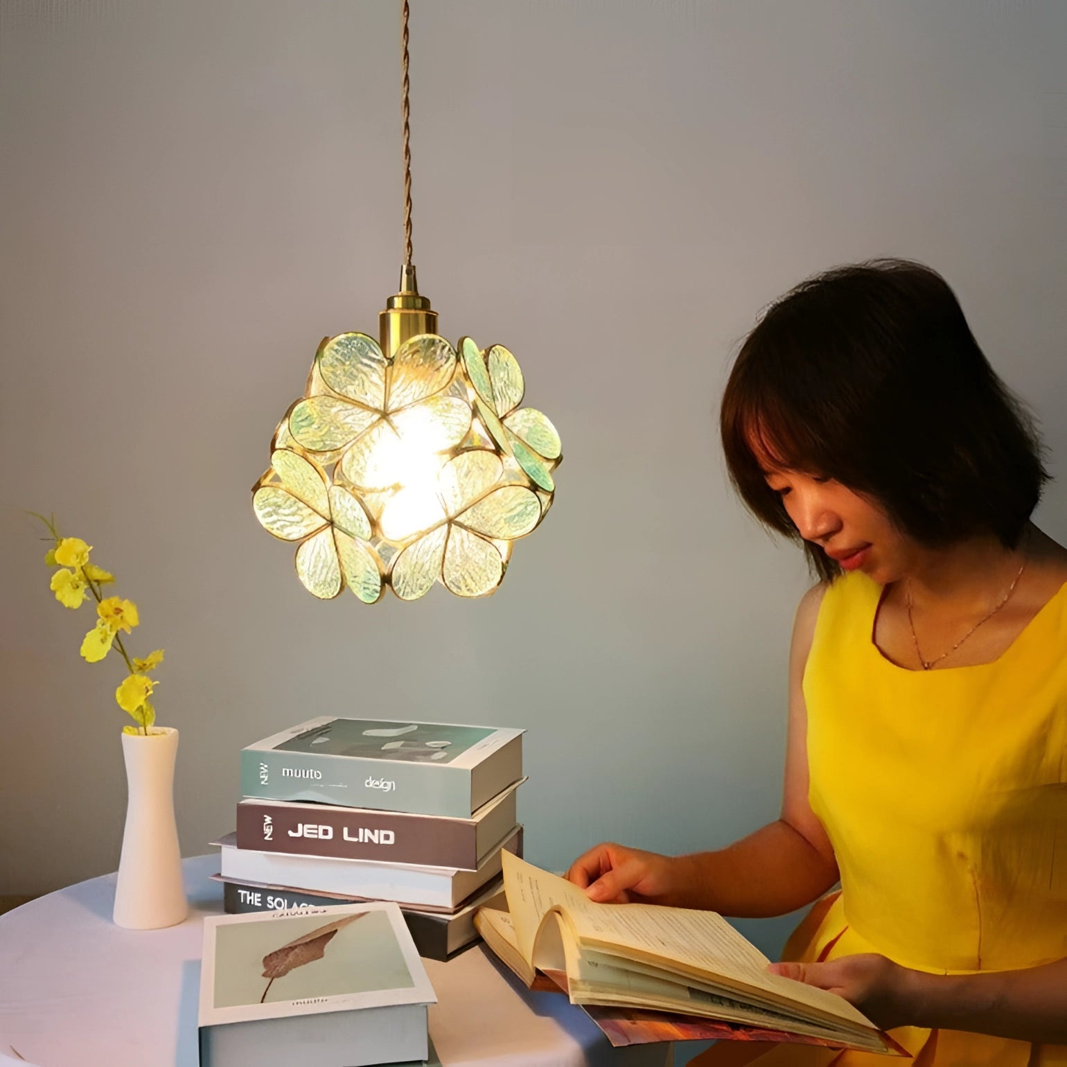 Modern designer floral pendant light in yellow with blossom design, illuminating a room with soft light, featuring a stylish lampshade.