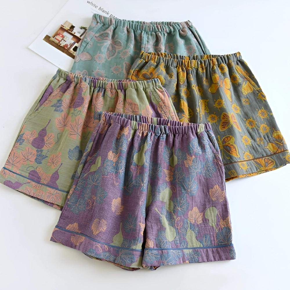 A pair of floral print pants featuring a ginkgo leaf design and an elastic waistband, displayed on a clothes hanger.