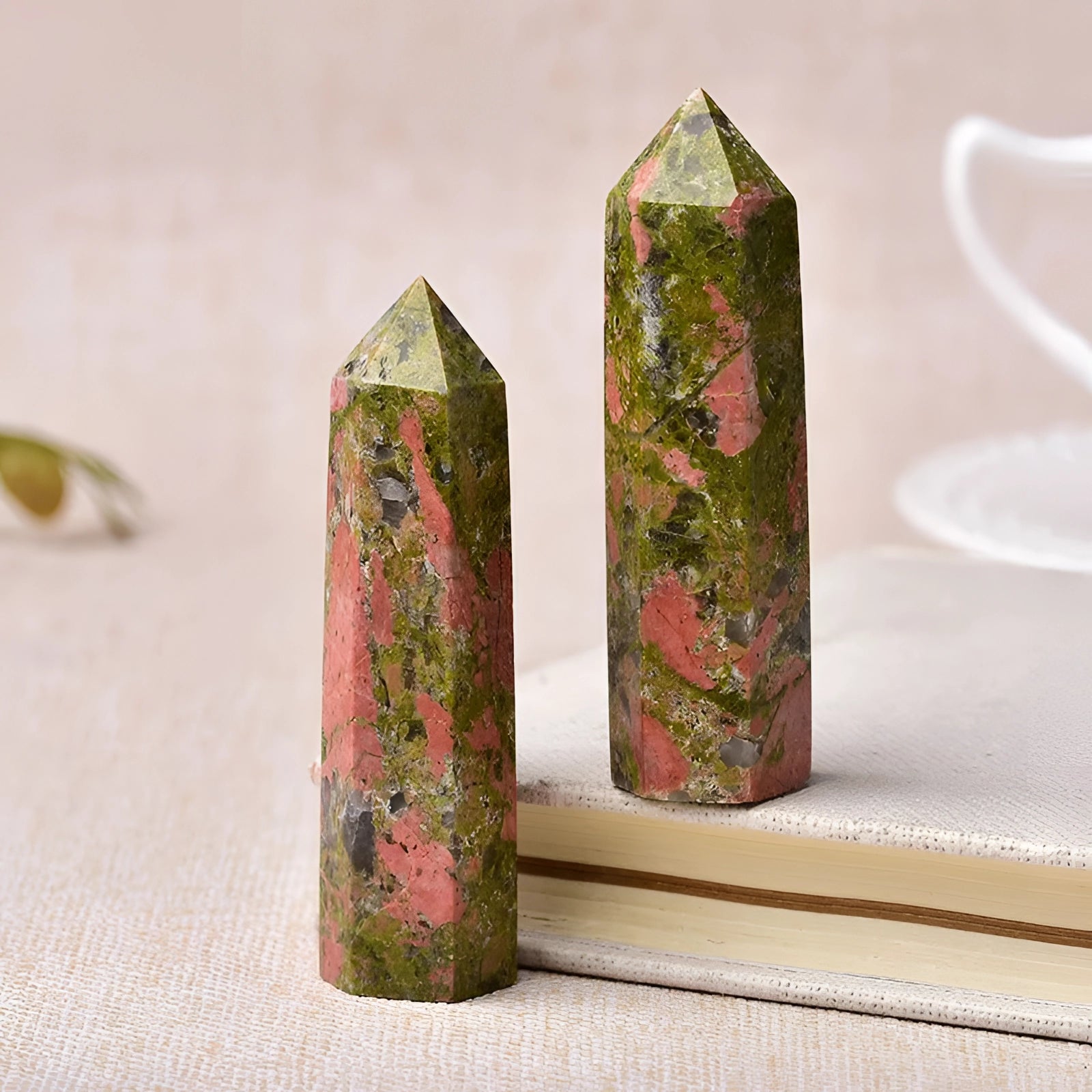 Purple and blue fluorite crystal tower with a smooth obelisk shape, standing on a surface.