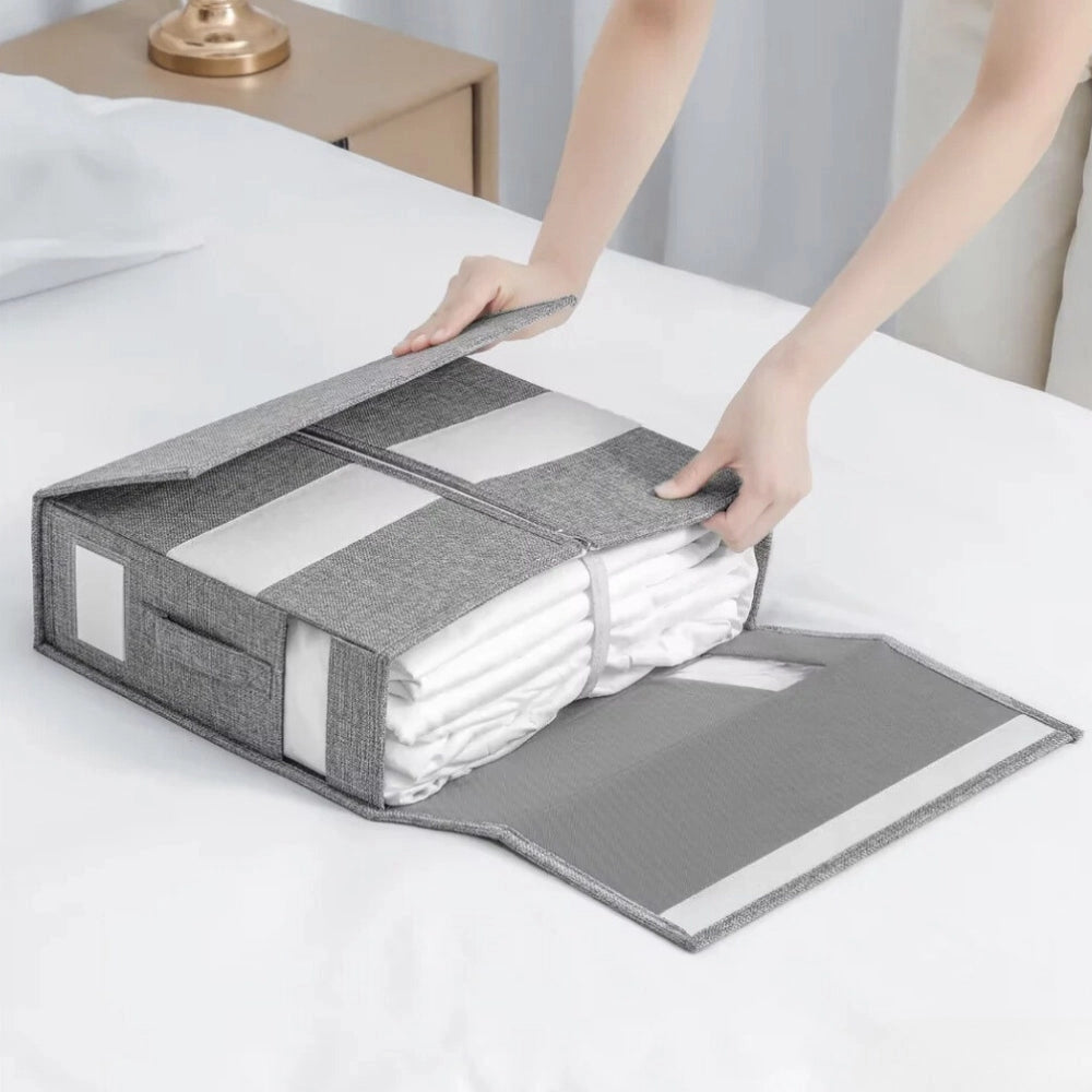 Foldable zipper storage bag in gray fabric with a rectangular shape, designed for organizing quilts and bedding, placed on a wooden surface.