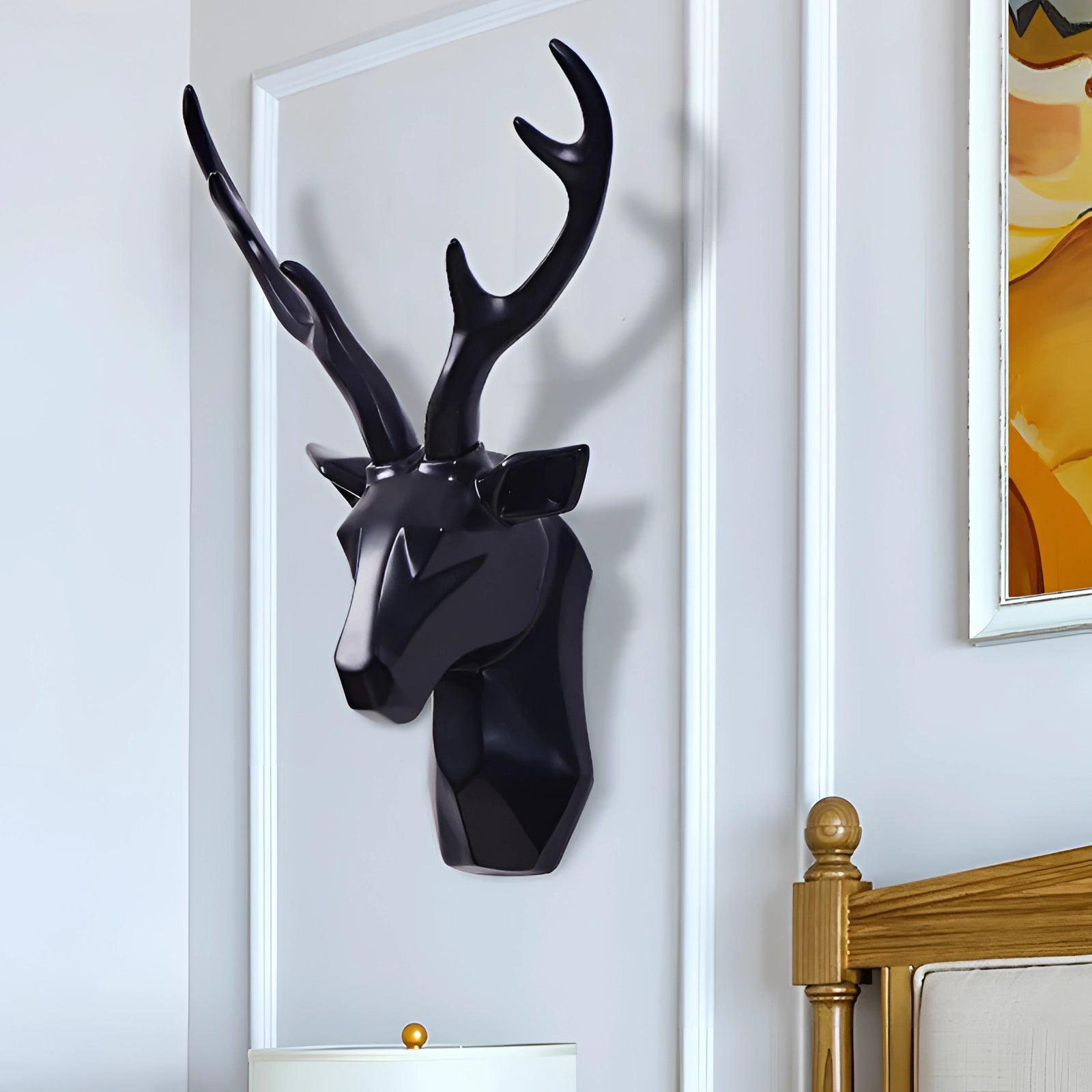 
A modern geometric deer head art piece in gold, featuring a 3D stag design mounted on a rectangular wooden frame, against a white and grey background.