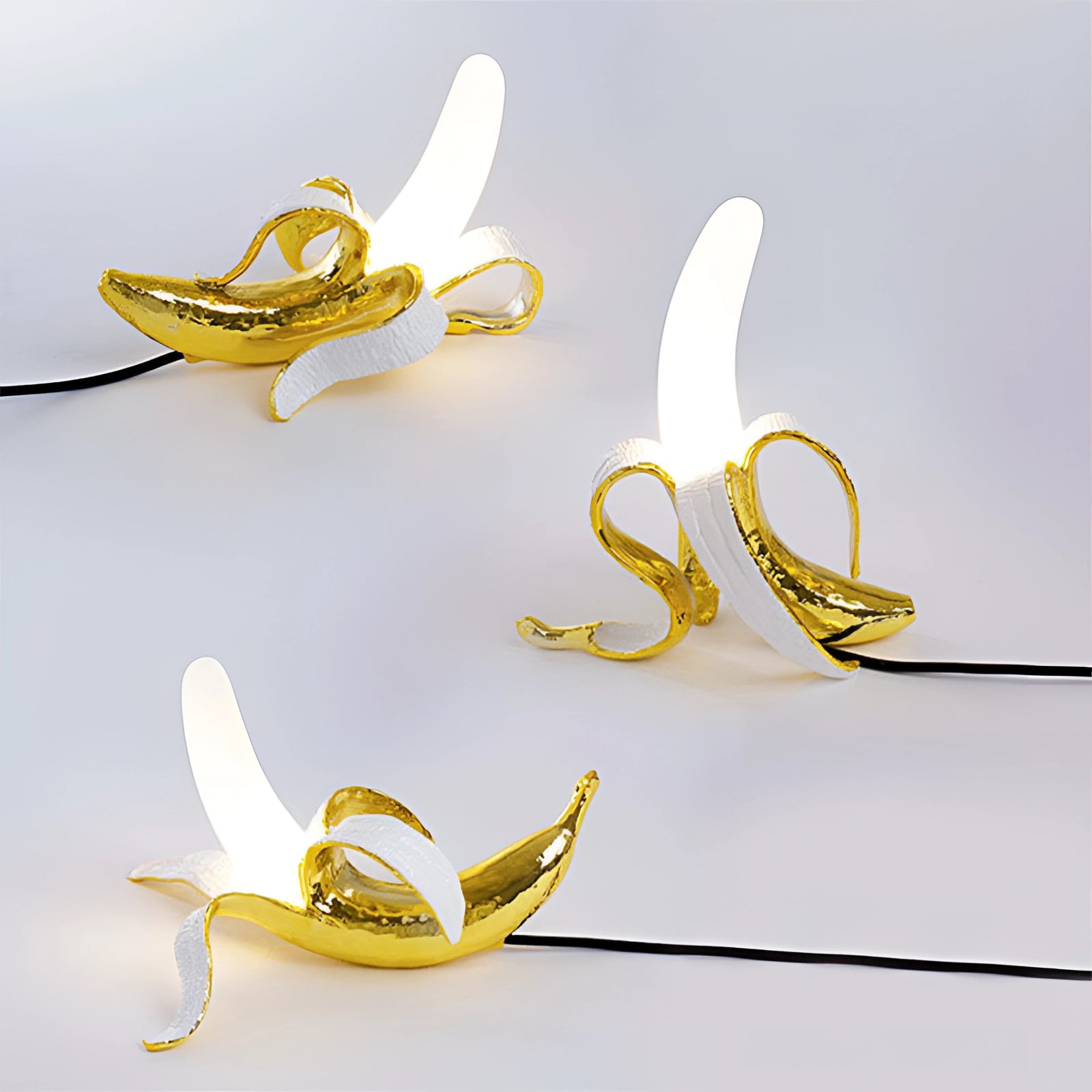 Gold Banana Resin Table Lamp featuring a modern art fruit sculpture design with a sleek gold and yellow finish.