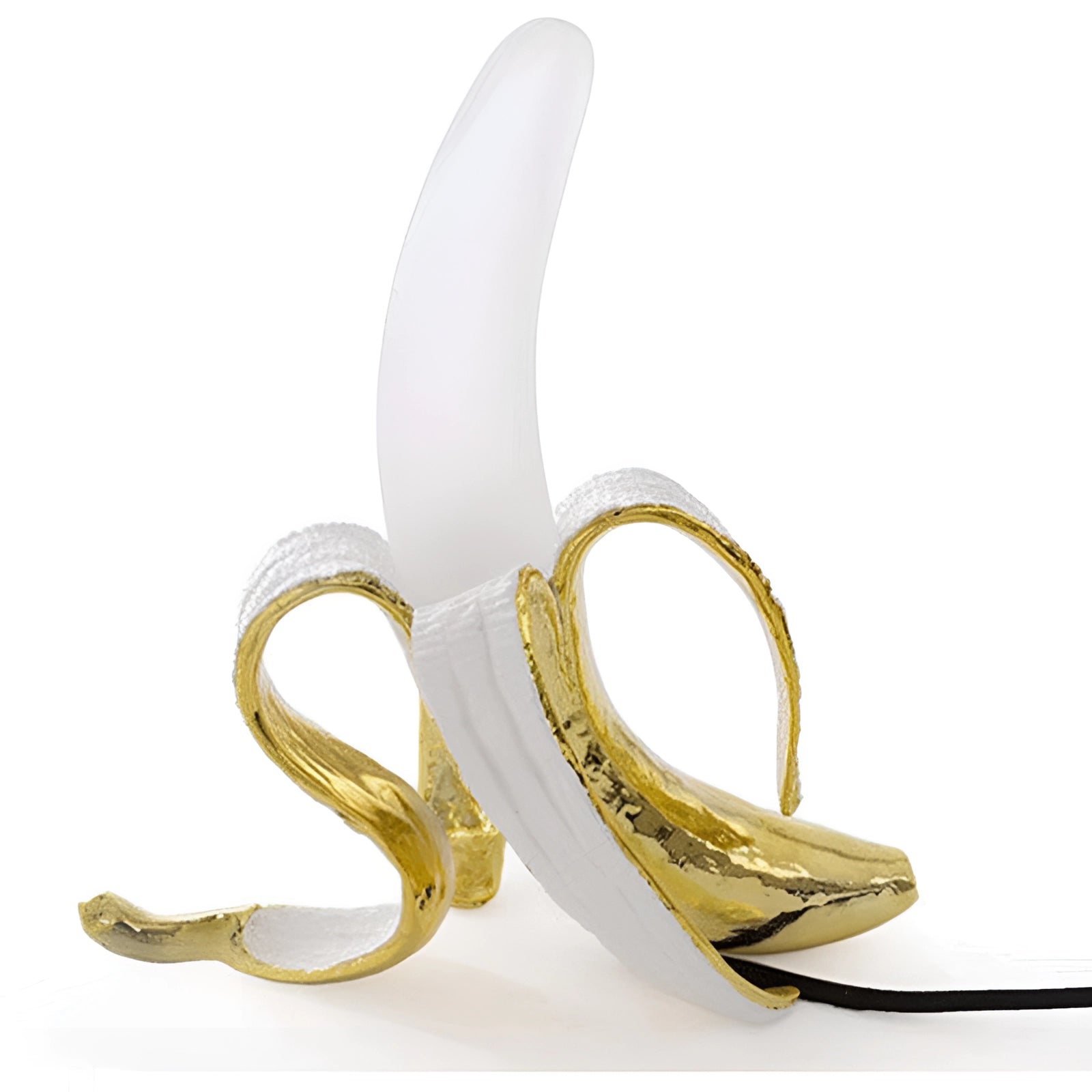 Gold banana-shaped resin table lamp designed as a modern art fruit sculpture, with a golden finish, standing on a rectangular base, blending natural material aesthetics with contemporary decor.
