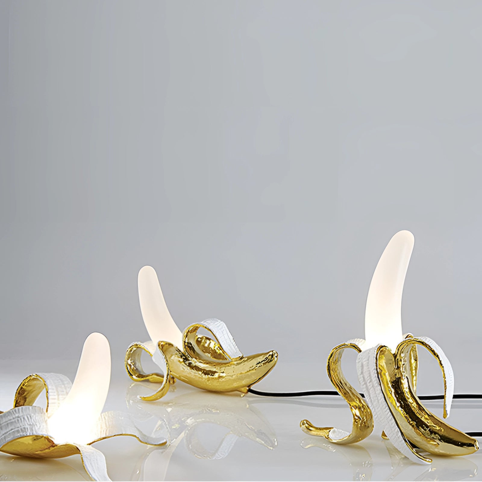 
A modern art sculpture decor table lamp in the shape of a gold banana, featuring a sleek and artistic design.
