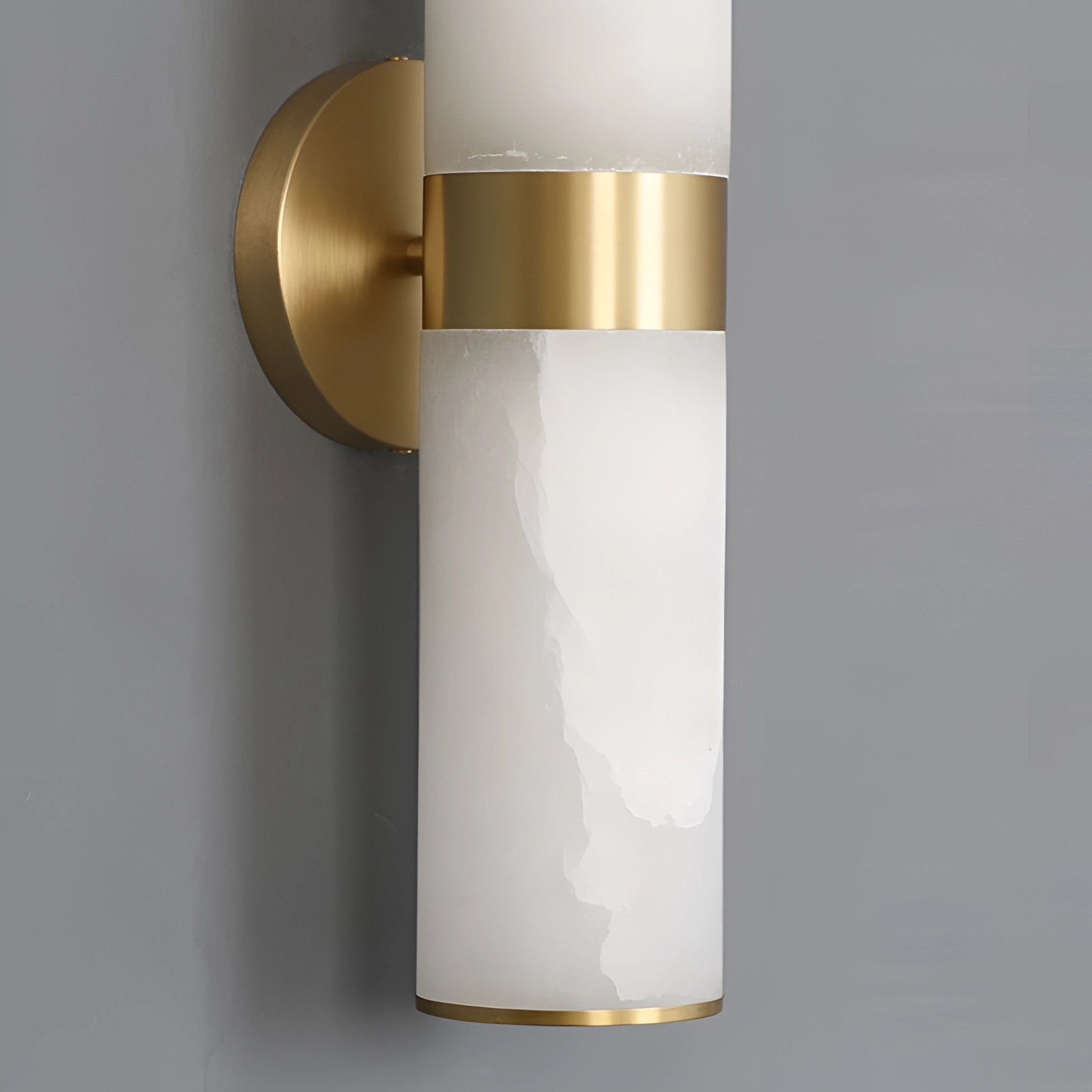 Gold bathroom sconce with a cylindrical frosted glass wall light, featuring a sleek metal finish.