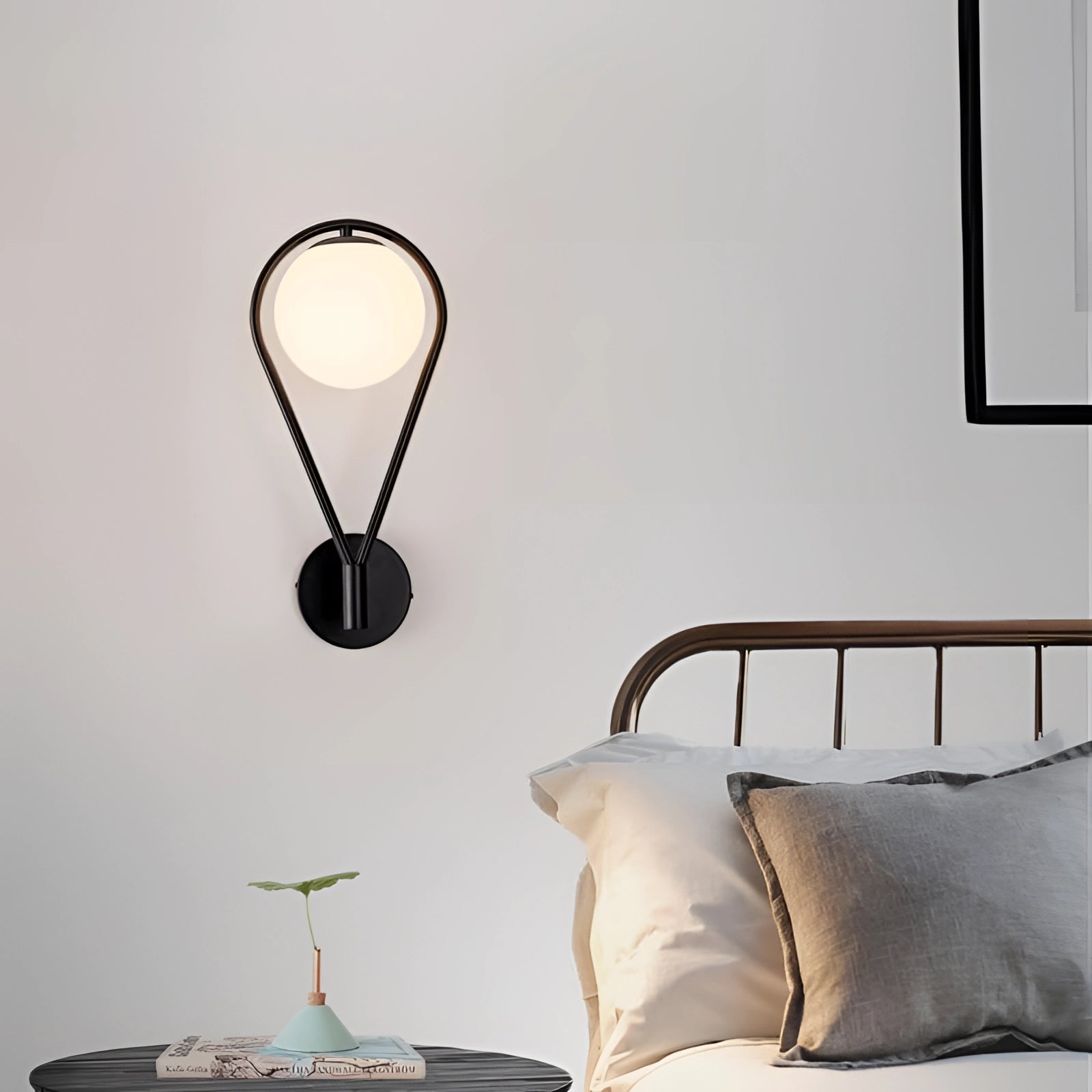 Gold brass wall sconce with a modern geometric globe lamp design, illuminating a luxurious interior space with wood flooring.