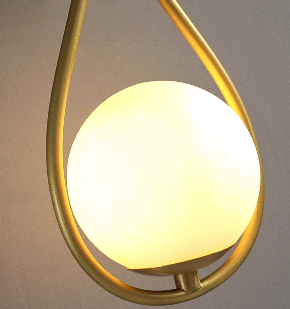 Gold brass wall sconce featuring a modern geometric globe lamp design, mounted on a wooden wall, with luxurious lighting elements and circular metal accents.