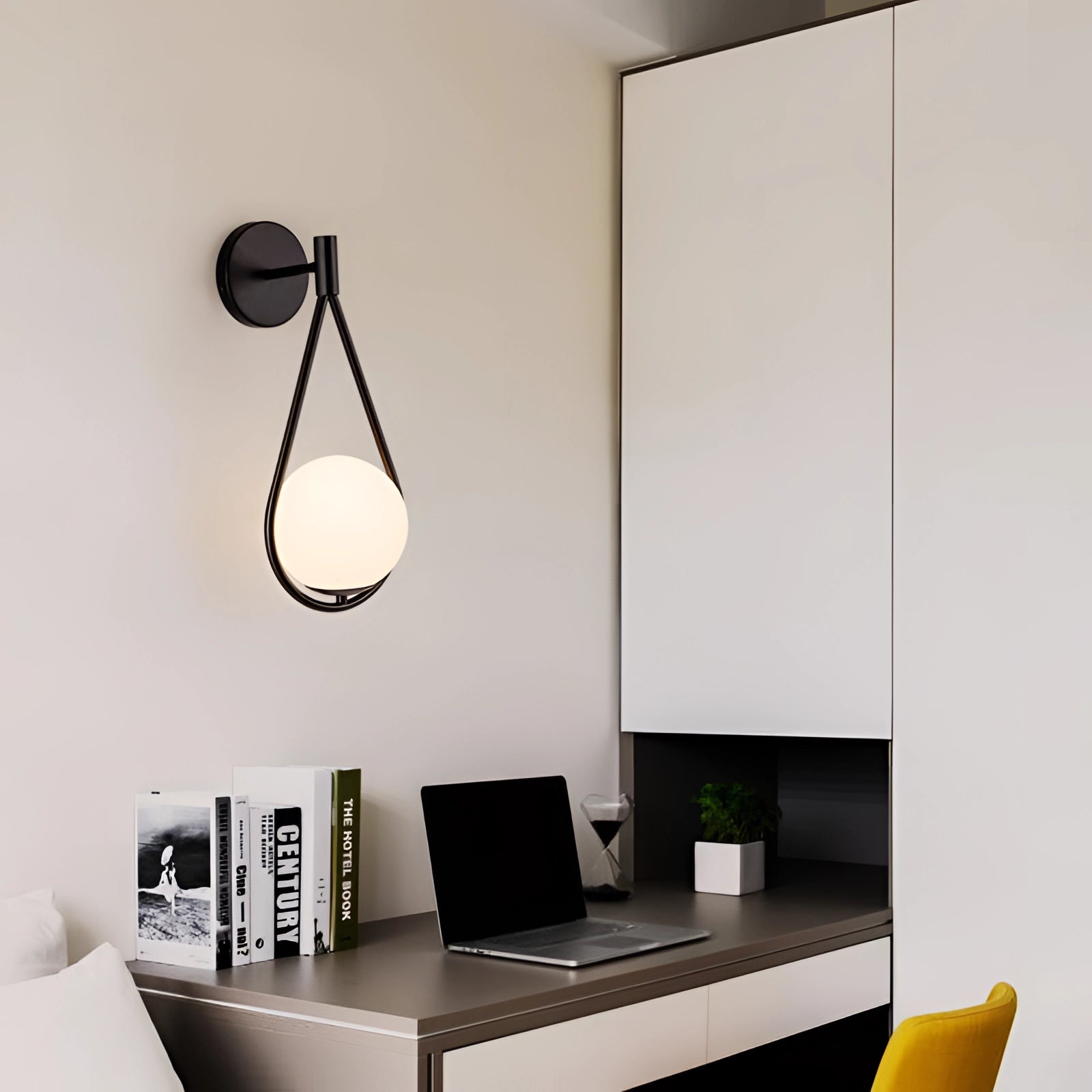 Gold Brass Wall Sconce with Modern Geometric Globe design illuminating a contemporary interior with grey couch and wooden table.