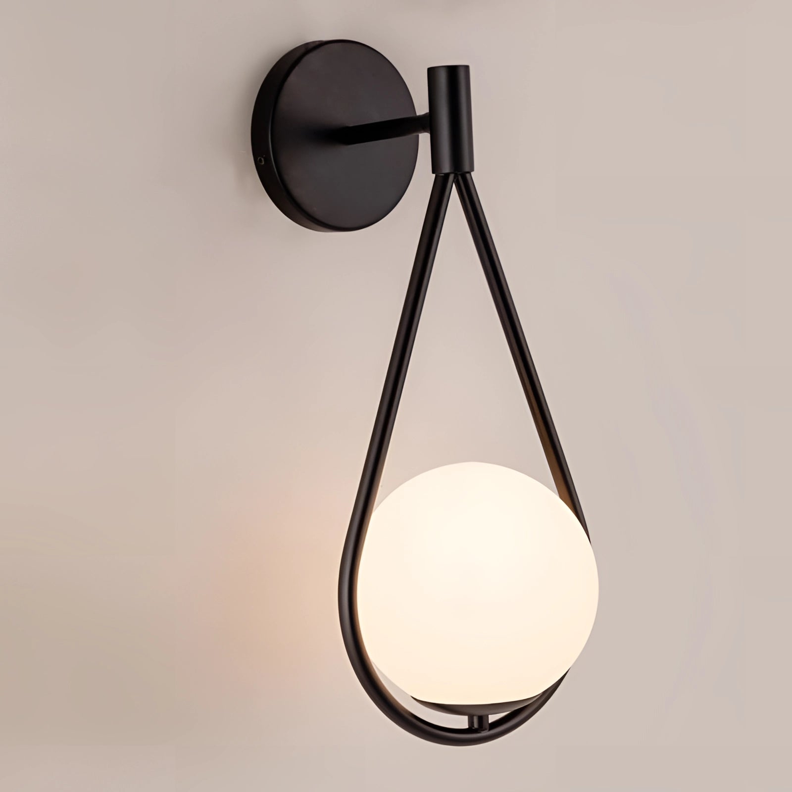 Modern geometric globe lamp in black with gold brass accents, mounted on a wall, luxury lighting fixture.