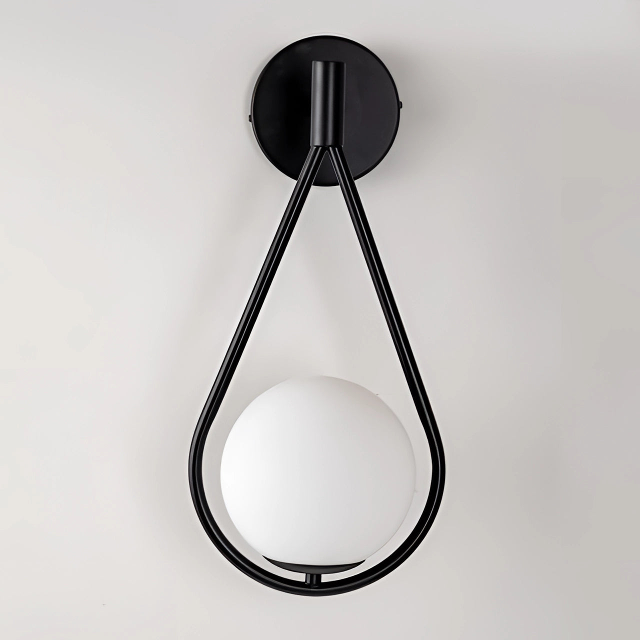 Modern geometric globe lamp in gold brass mounted on a wall, showcasing luxury lighting design with a spherical shape and elegant metal finish.