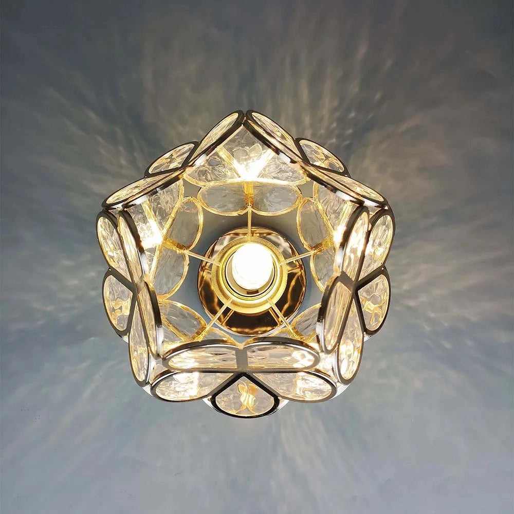 Gold flush mount ceiling light with an artistic glass design featuring a modern geometric style, showcasing amber and gold hues with symmetrical circular patterns.