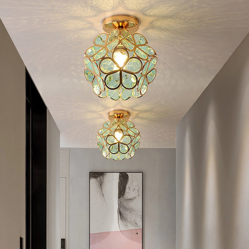 Gold flush mount ceiling light with artistic glass featuring a modern geometric design, elegantly integrated into an interior space.