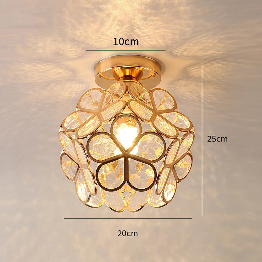 Gold flush mount artistic glass ceiling light with a modern geometric design, featuring amber-tinted glass and symmetrical elements, mounted on a ceiling.