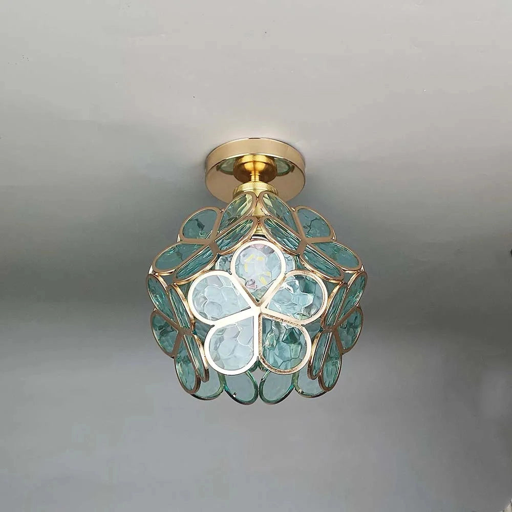 Modern geometric design ceiling light with a gold flush mount, featuring artistic glass in shades of green. The fixture embodies an ornamental style with symmetrical circular patterns, resembling a chandelier and adding an artistic touch to the ceiling decor.
