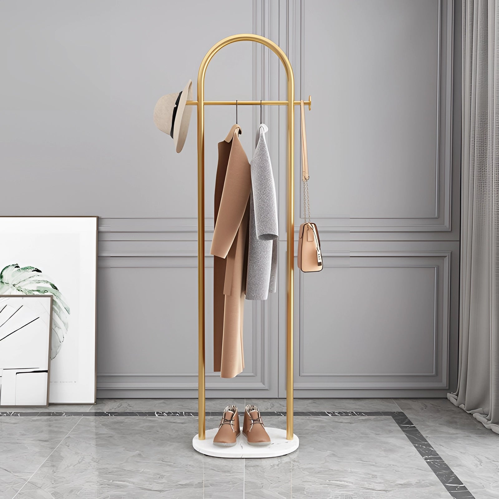 Gold metal coat rack with a marble base, featuring a minimalist design and luxury finish.