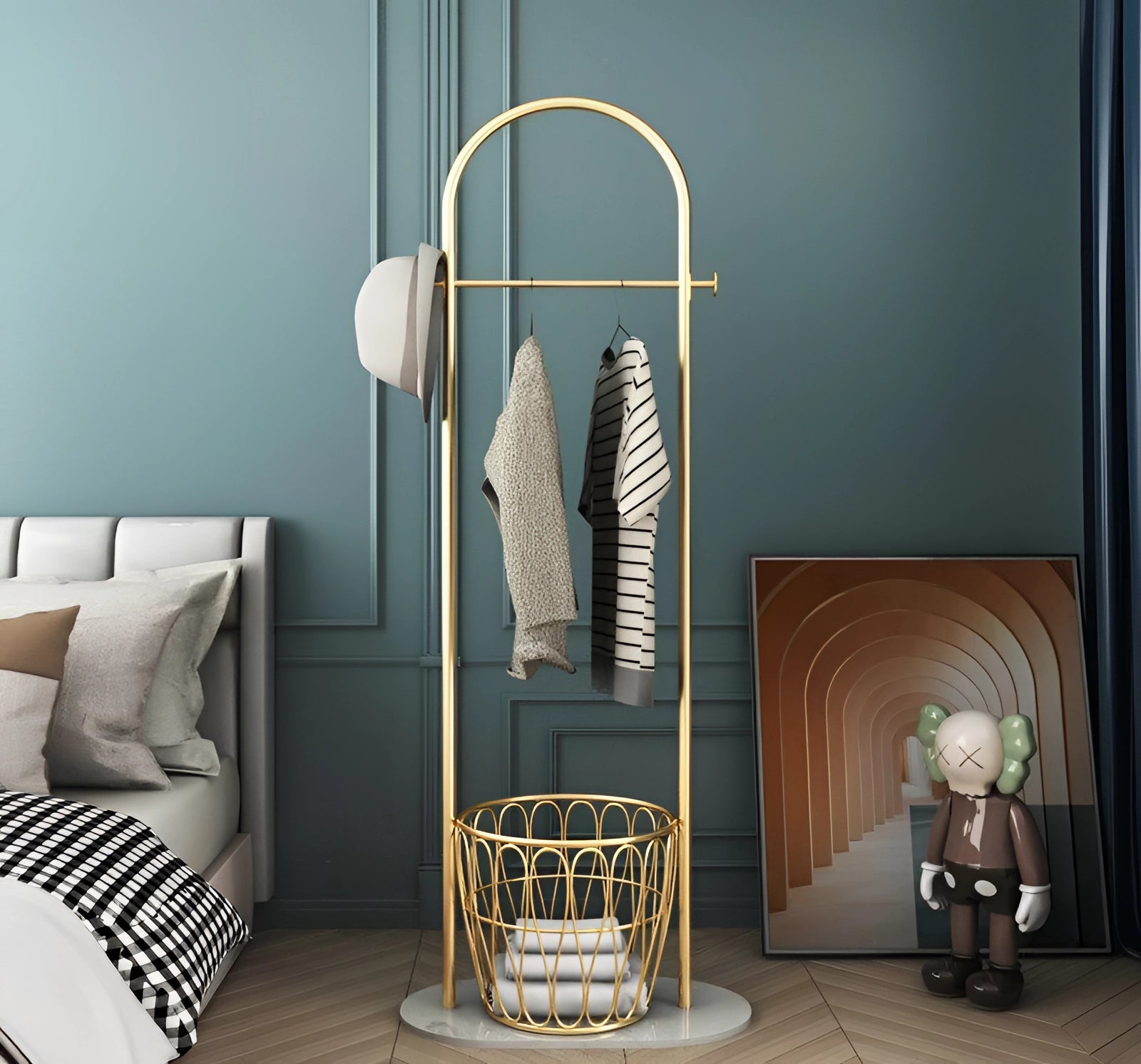 Sleek gold metal coat rack with a sturdy white marble base standing on a grey floor, designed for a minimalist and luxury interior setting.
