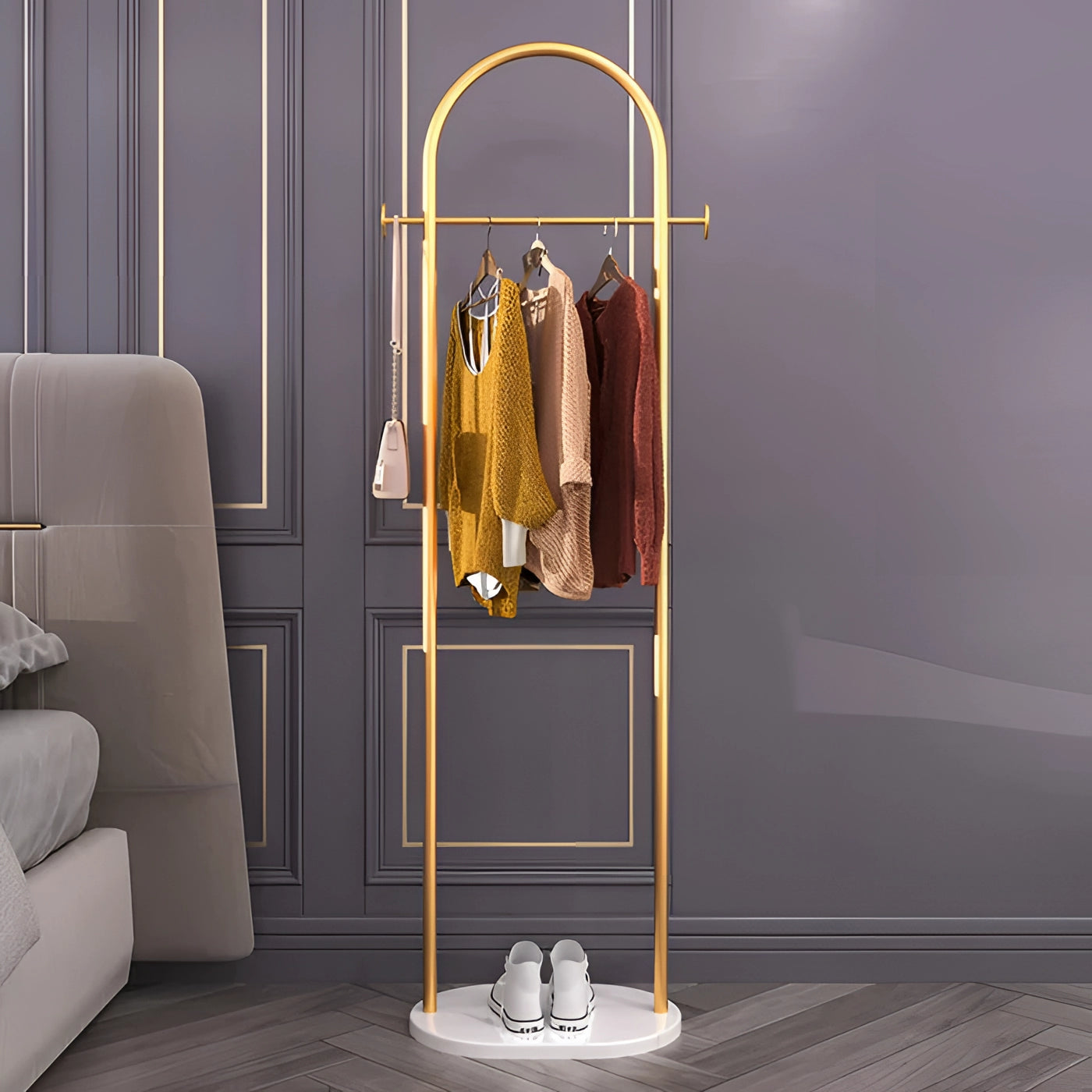 Gold metal coat rack with a marble base placed in a stylish interior setting, featuring a minimalist design.