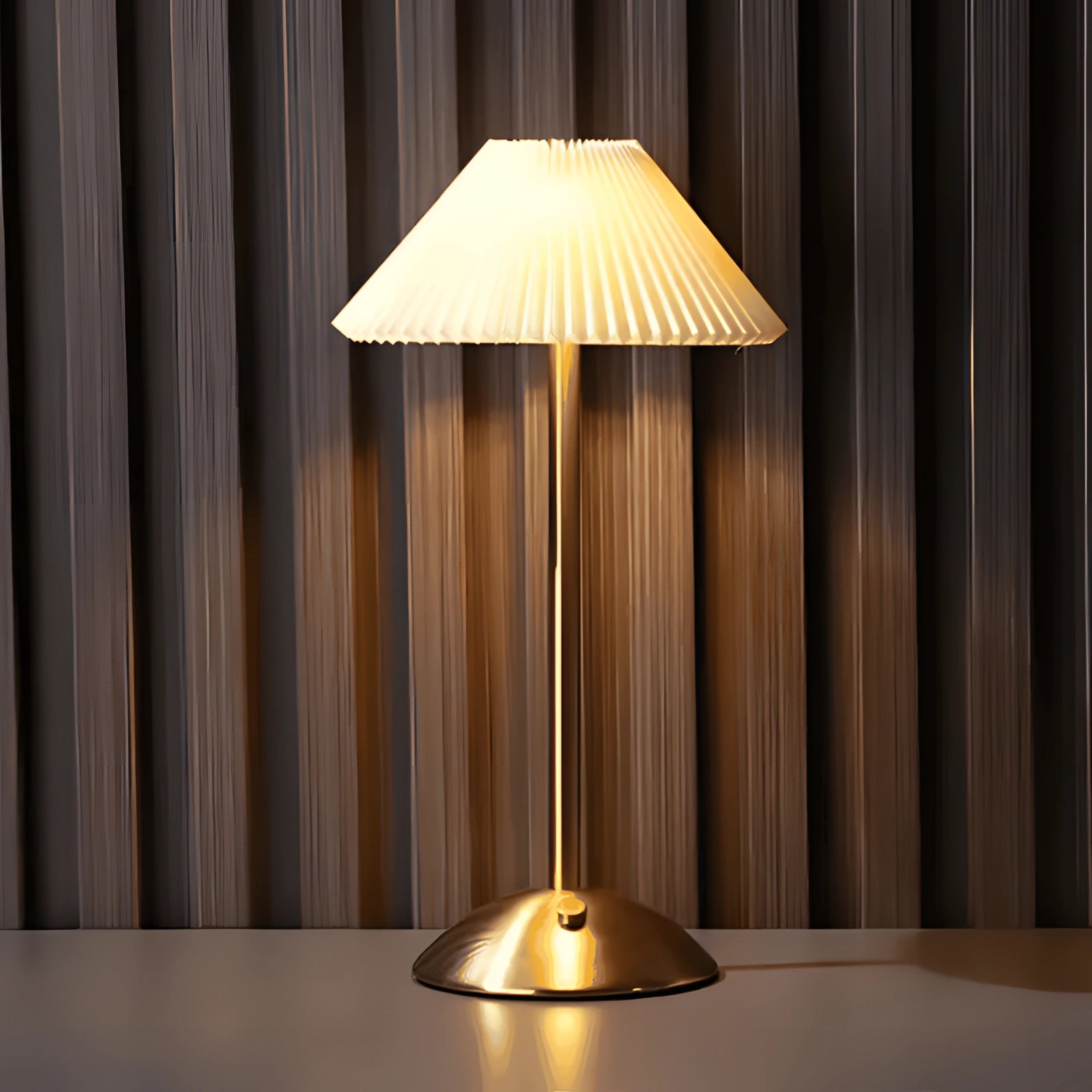 Gold mid-century brass floor lamp with a beige pleated lampshade, featuring a warm amber glow, ideal for interior design.