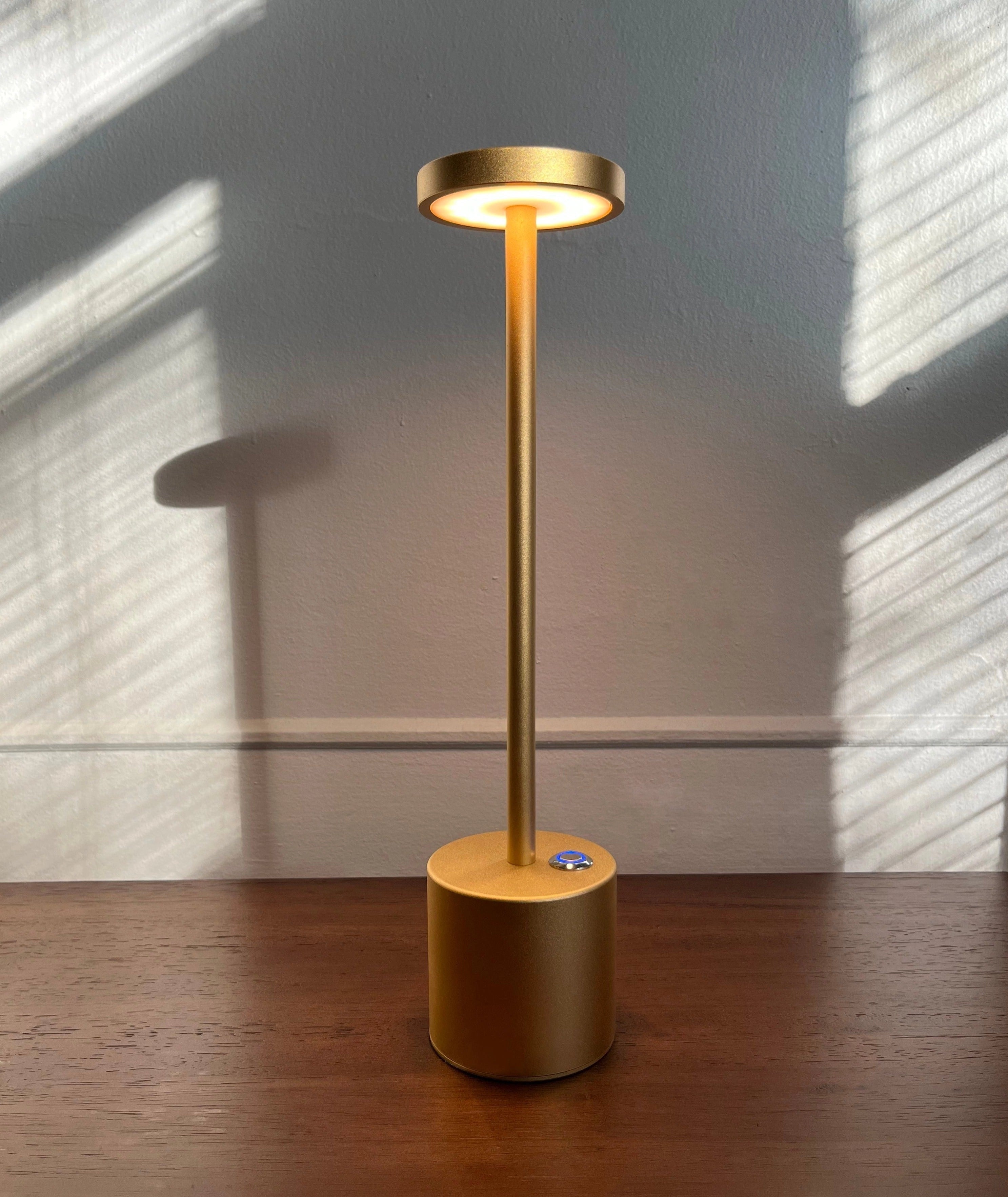 Gold Minimalistic LED Desk Lamp with Circular Head in Brass Finish on Wooden Desk