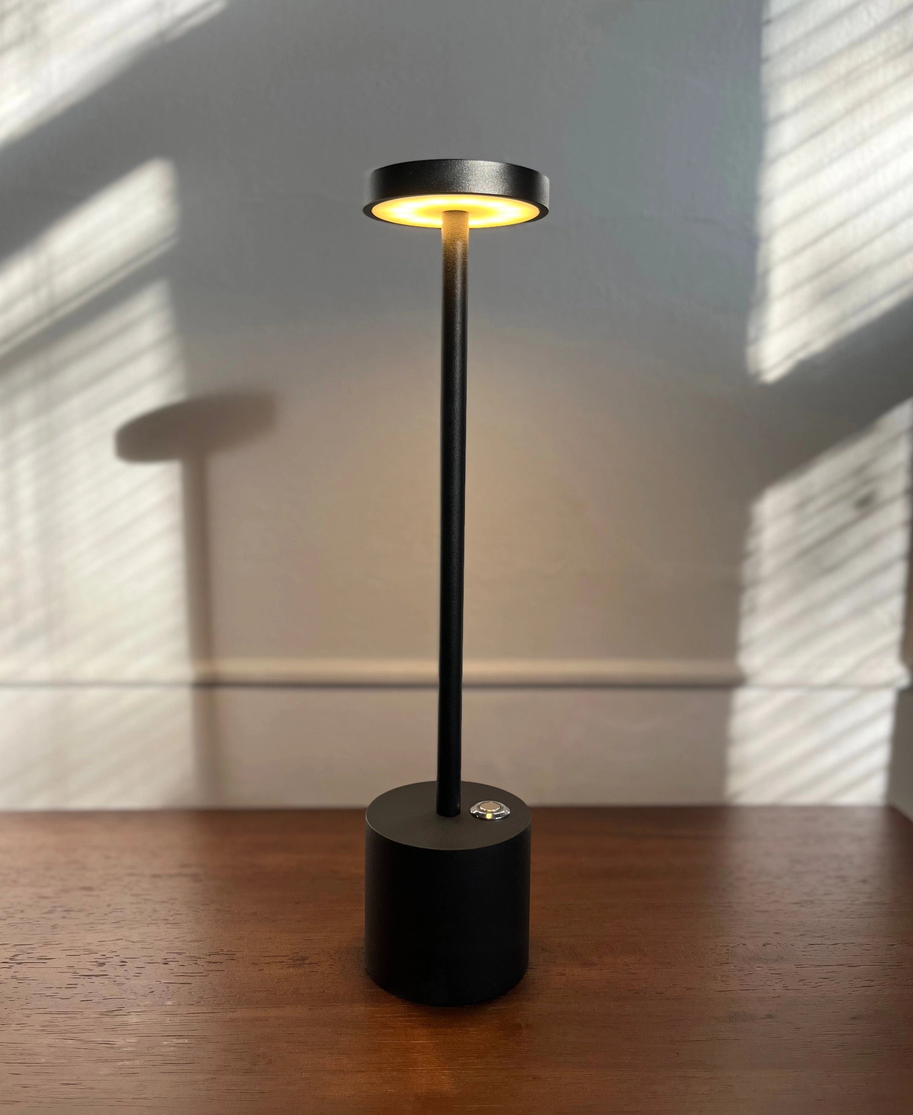 Gold Minimalistic LED Desk Lamp with Circular Head and Brass Finish on a wooden surface background.