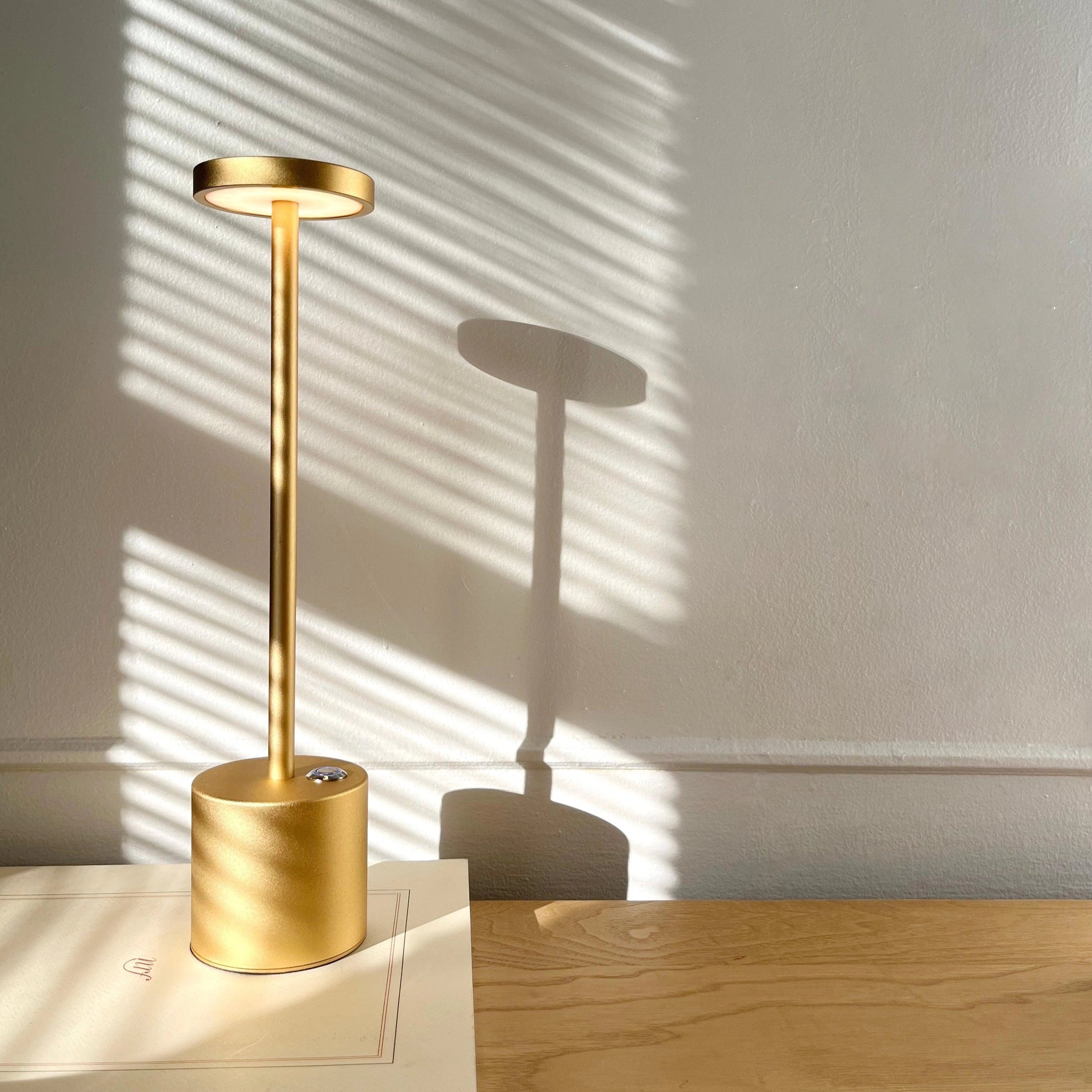 Gold Minimalistic LED Desk Lamp with Circular Head and Brass Finish on Wooden Desk
