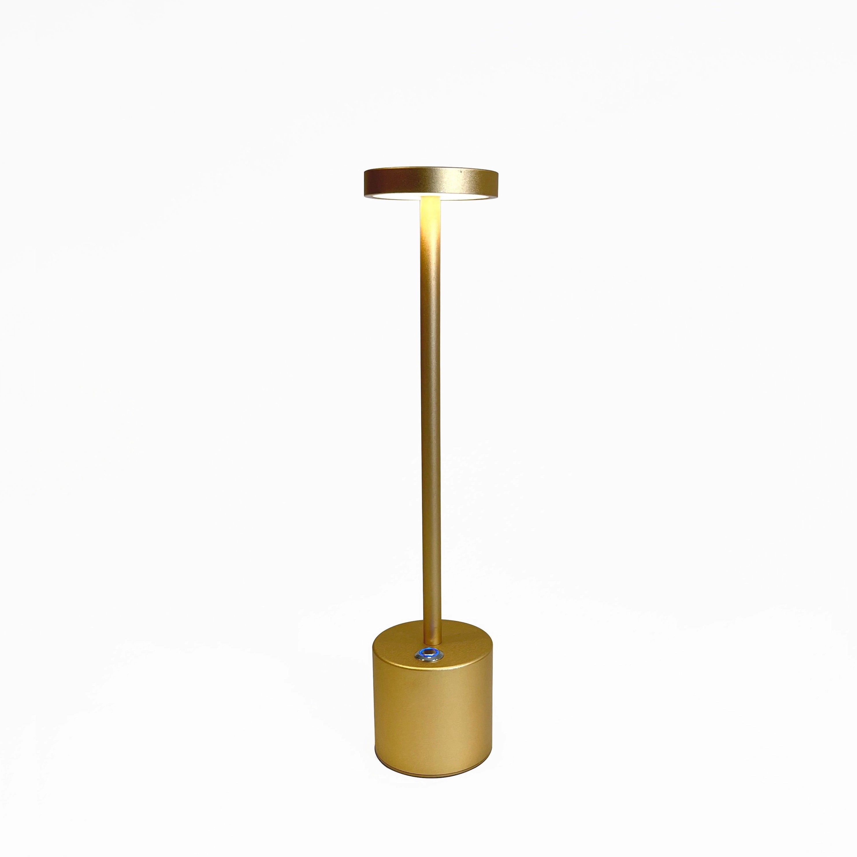 Gold minimalistic LED desk lamp with a circular head and stylish brass finish, placed on a wooden surface.