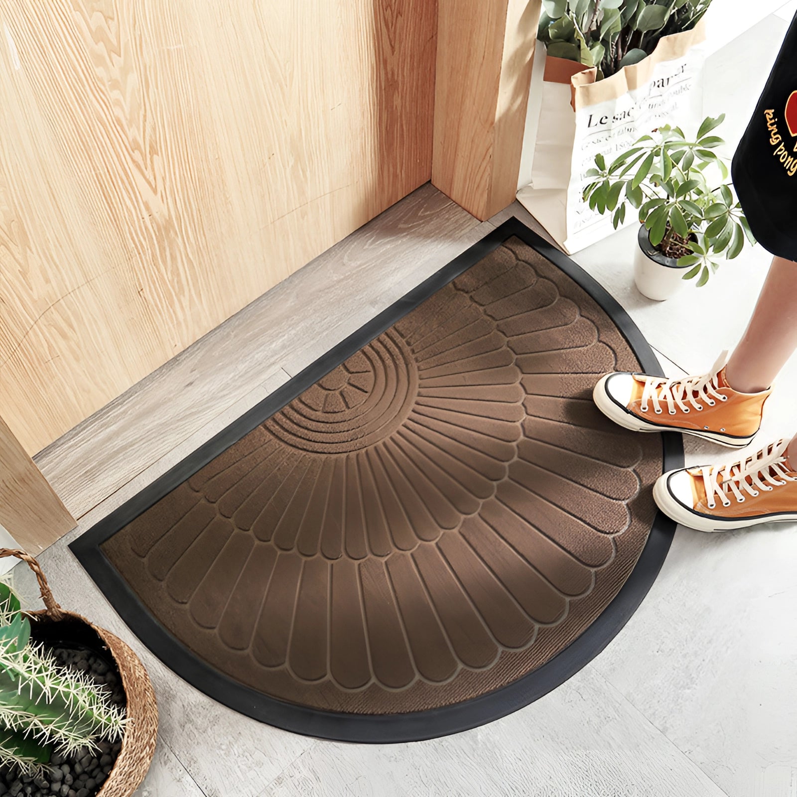 Gray semi-circular non-slip door mat on hardwood floor, featuring an absorbent and durable design, with a subtle pattern and Braun color variant measuring 60 x 90 cm.