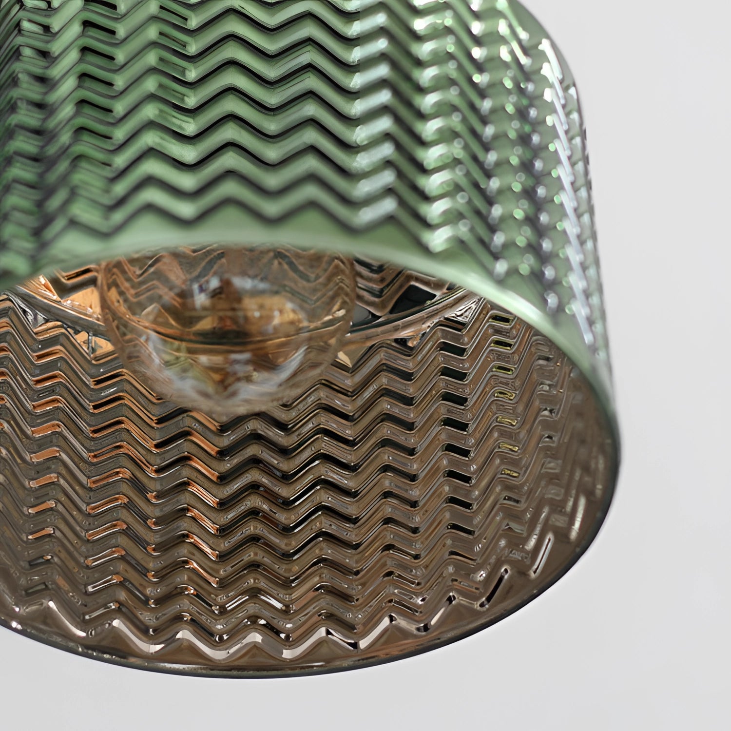 Green Chevron Wall Lamp featuring a brass sconce with a geometric pattern.