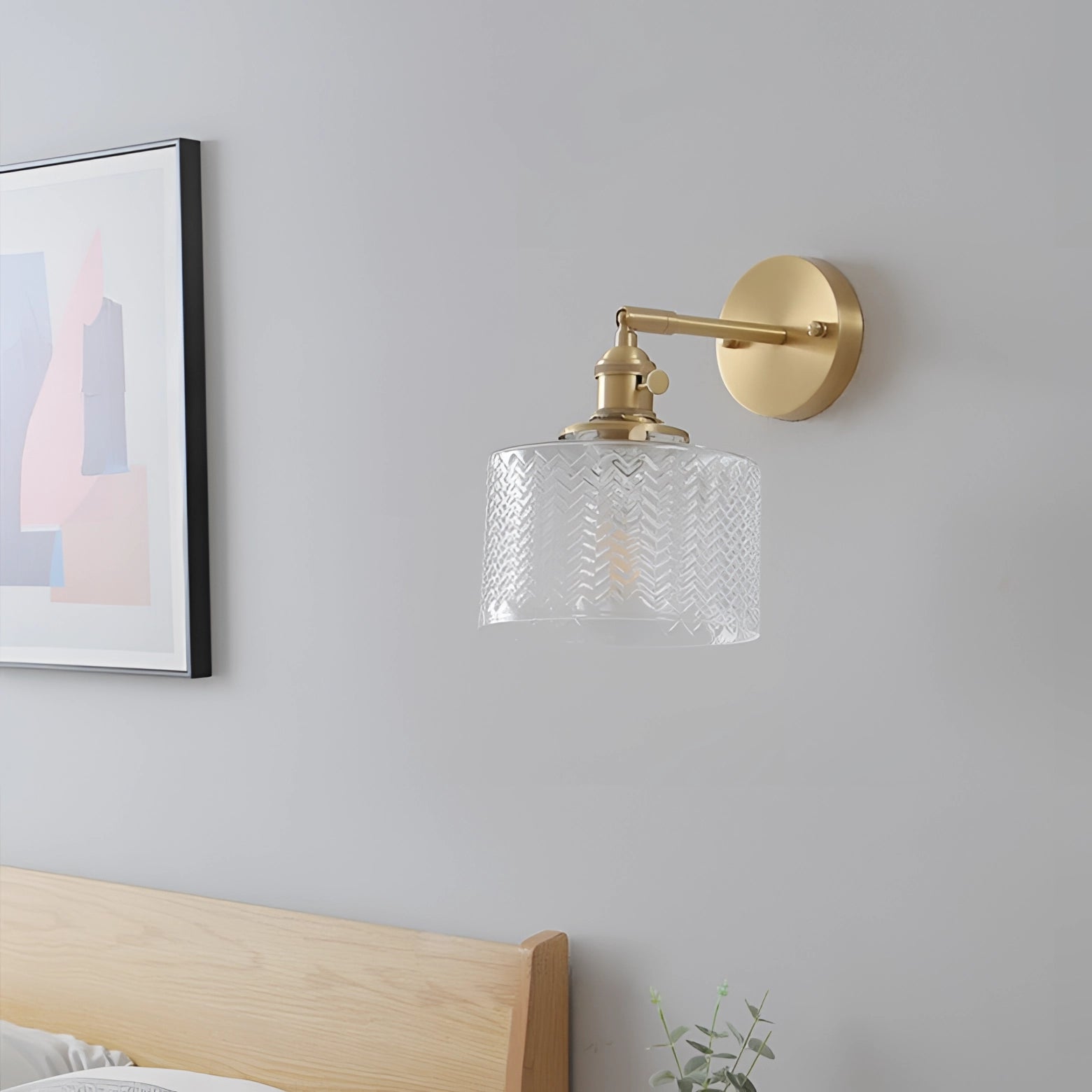 Green Chevron Wall Lamp featuring a brass sconce with a geometric pattern, displayed against a grey wall in a modern interior design setting.